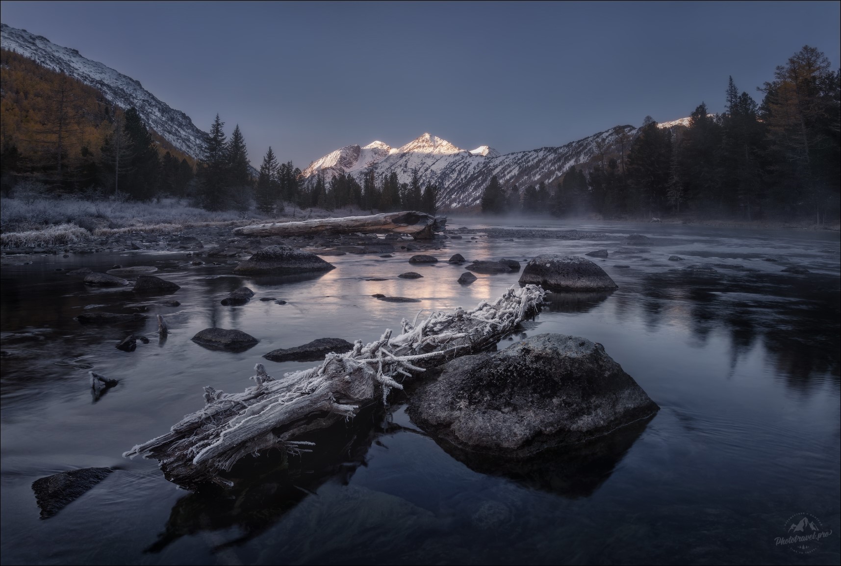 Frosty log in a river with snowy mountains at sunrise HD Wallpaper