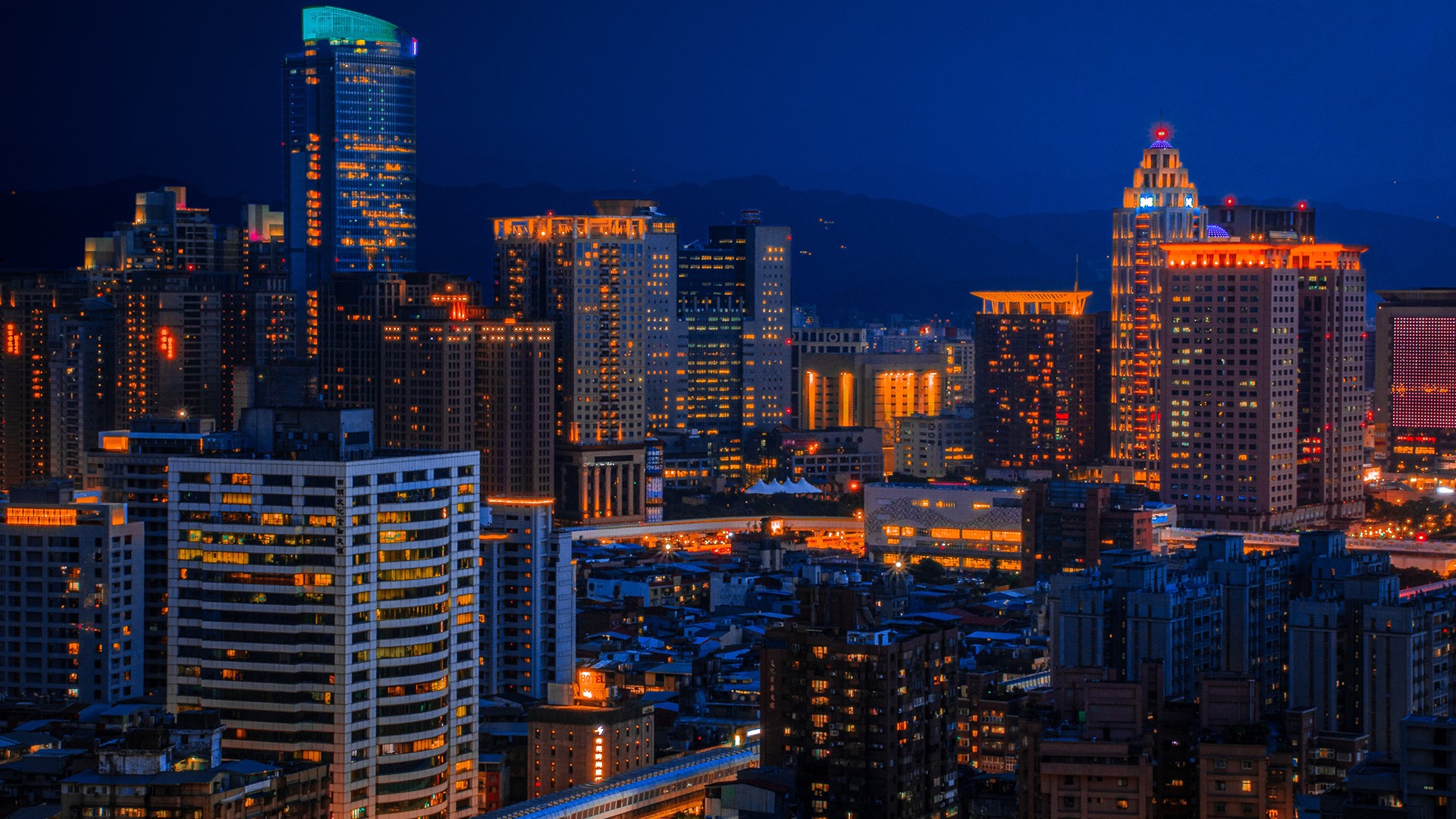City skyline at night with illuminated buildings HD Wallpaper