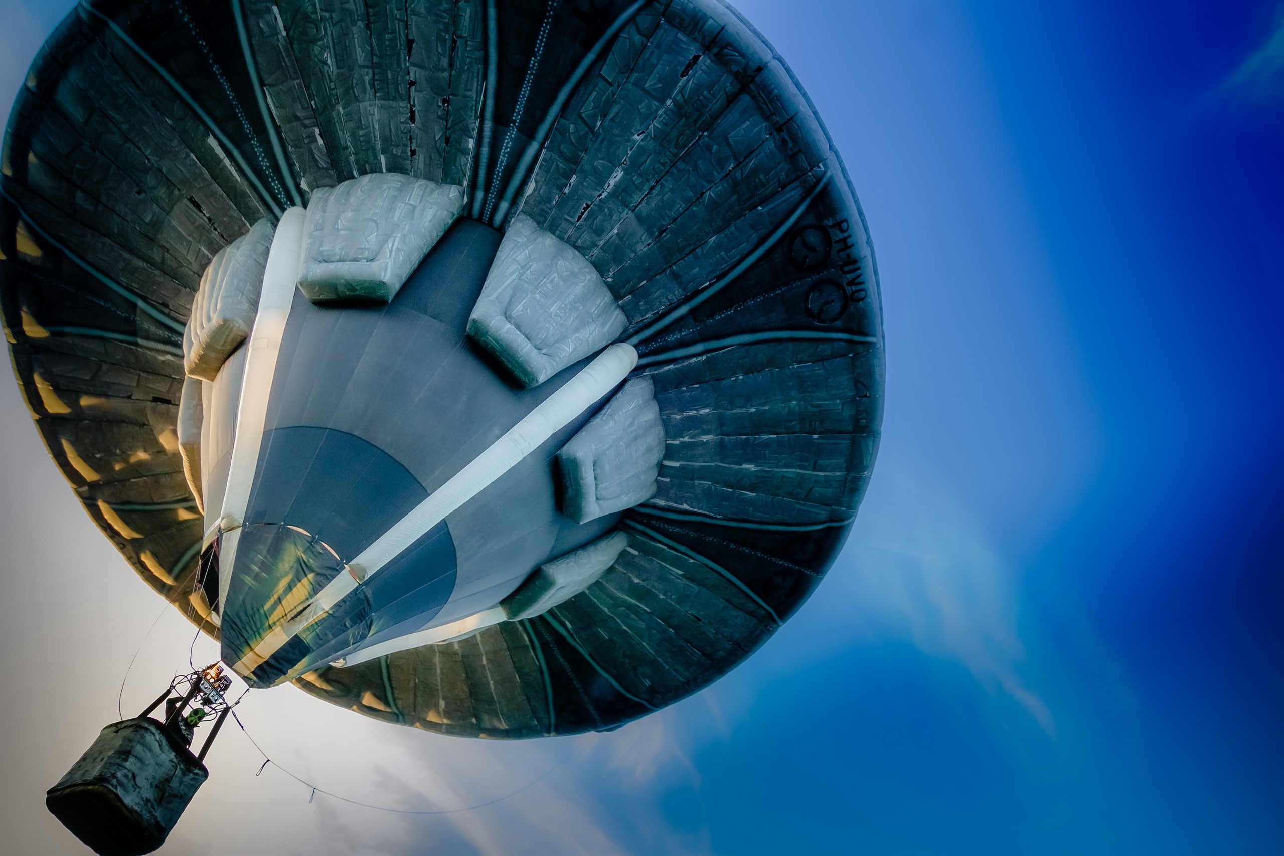 Hot air balloon from below against blue sky HD Wallpaper