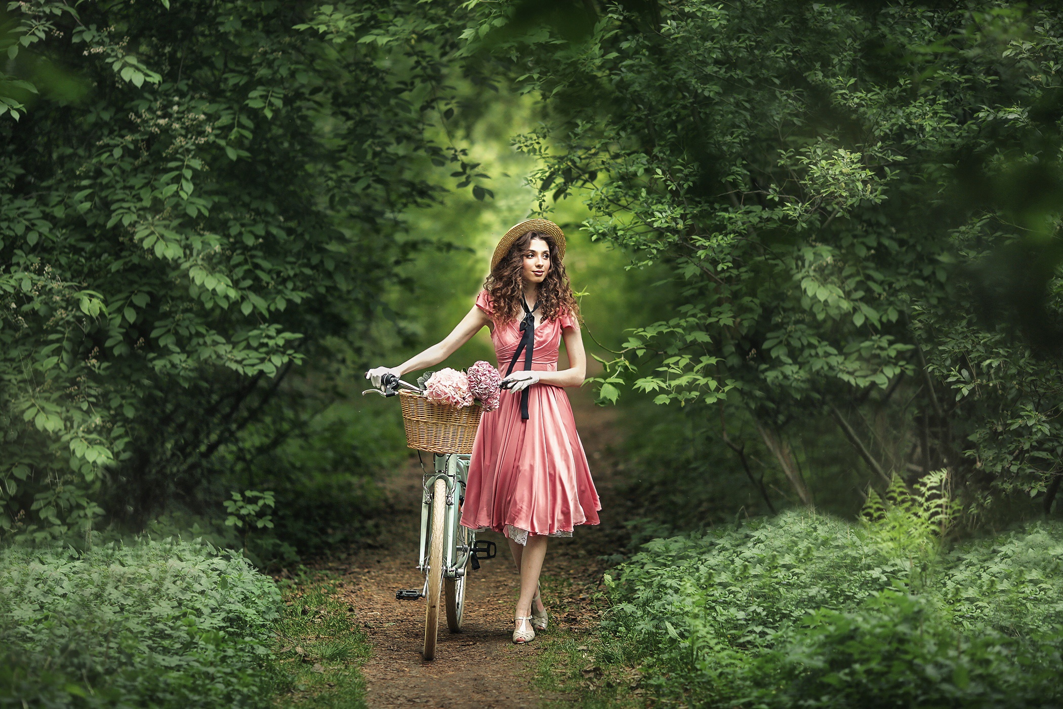 Woman in pink dress with bicycle in forest HD Wallpaper