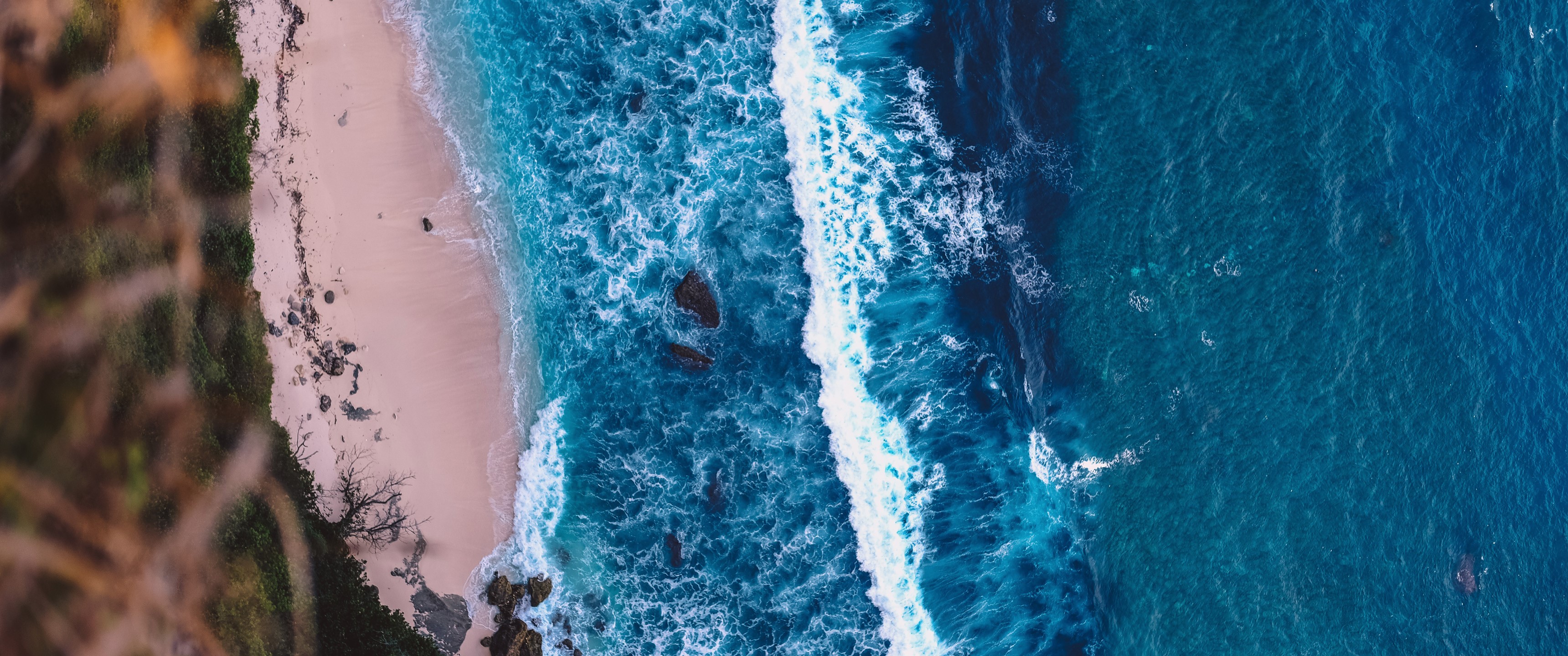 Aerial view of a tropical beach with turquoise waves HD Wallpaper