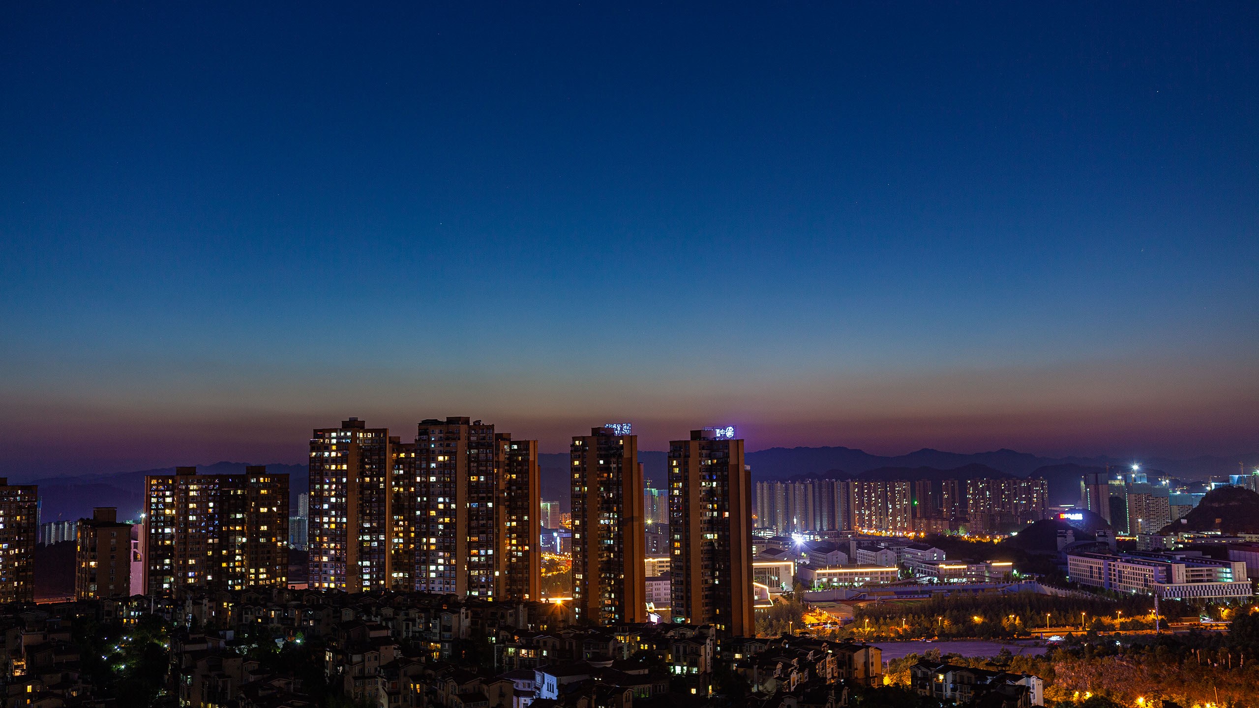 Cityscape at dusk with illuminated buildings in China HD Wallpaper