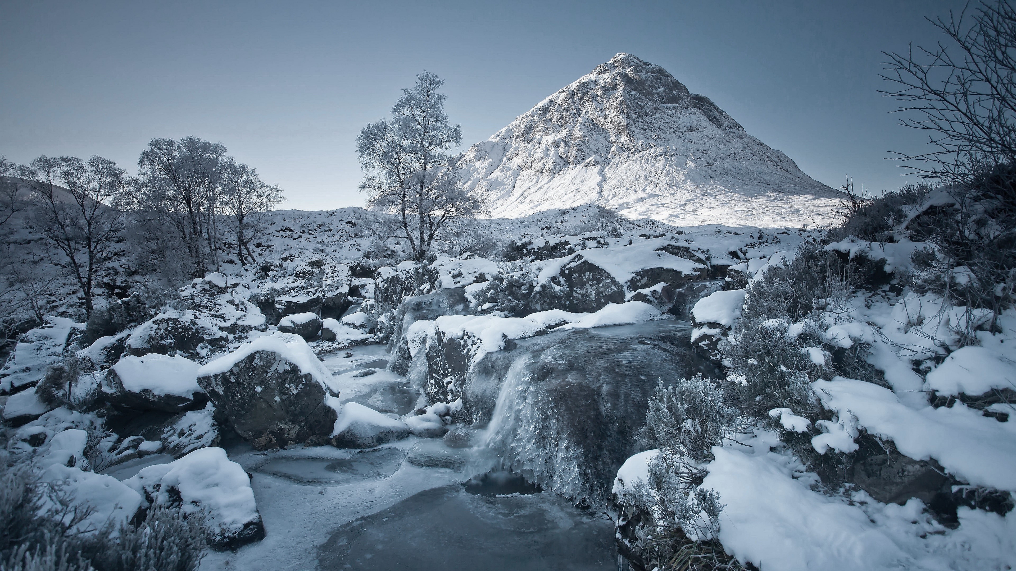 Winter landscape with snow-covered mountain and frozen stream HD Wallpaper