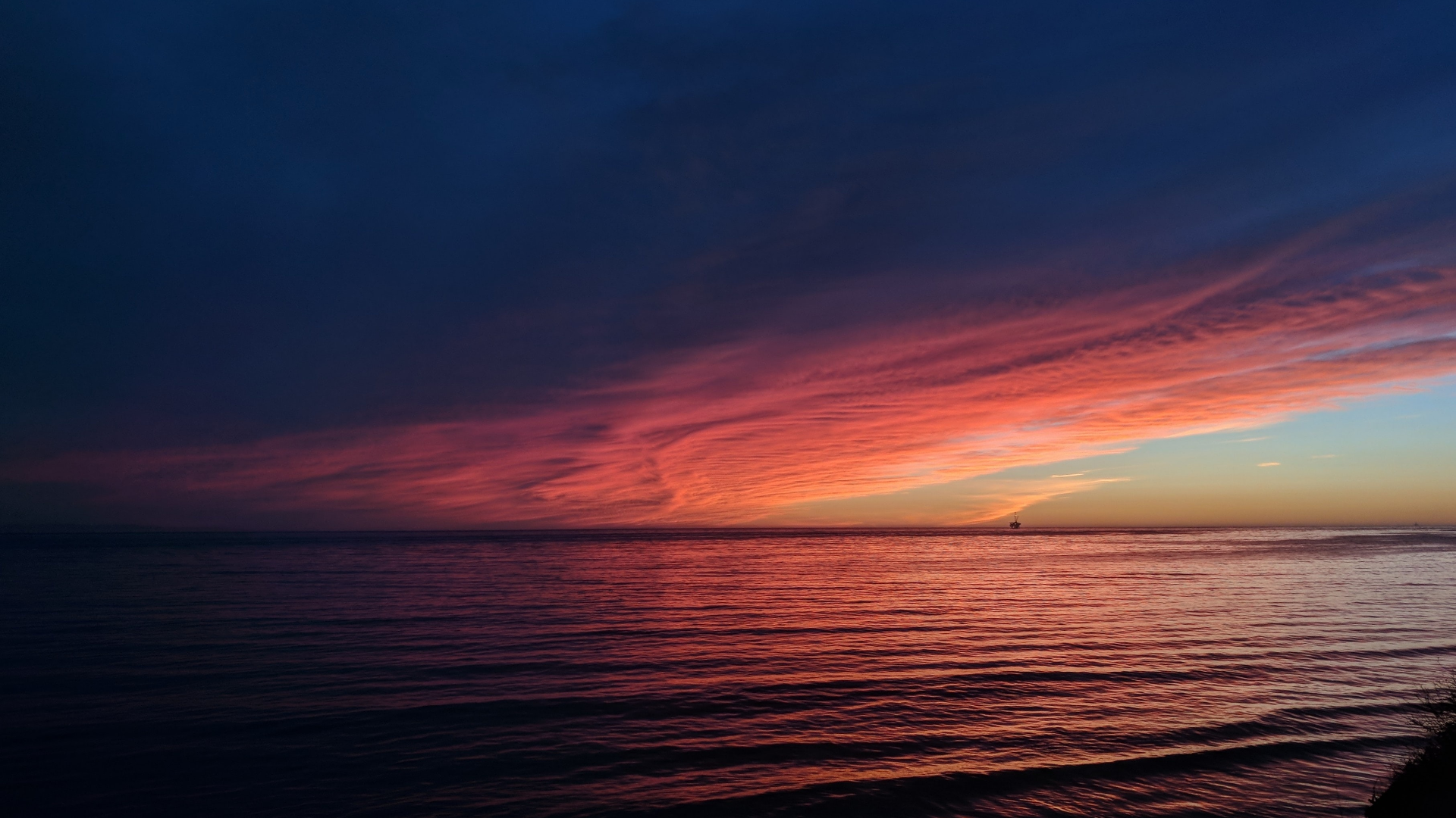 Sunset over the ocean with colorful clouds and a distant ship HD Wallpaper