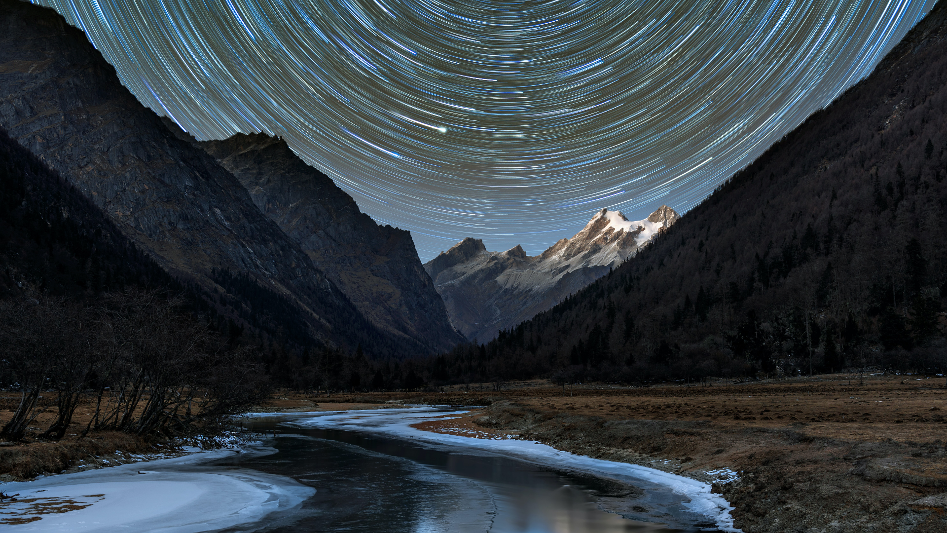 Star trails over mountains and frozen river in Sichuan, China HD Wallpaper
