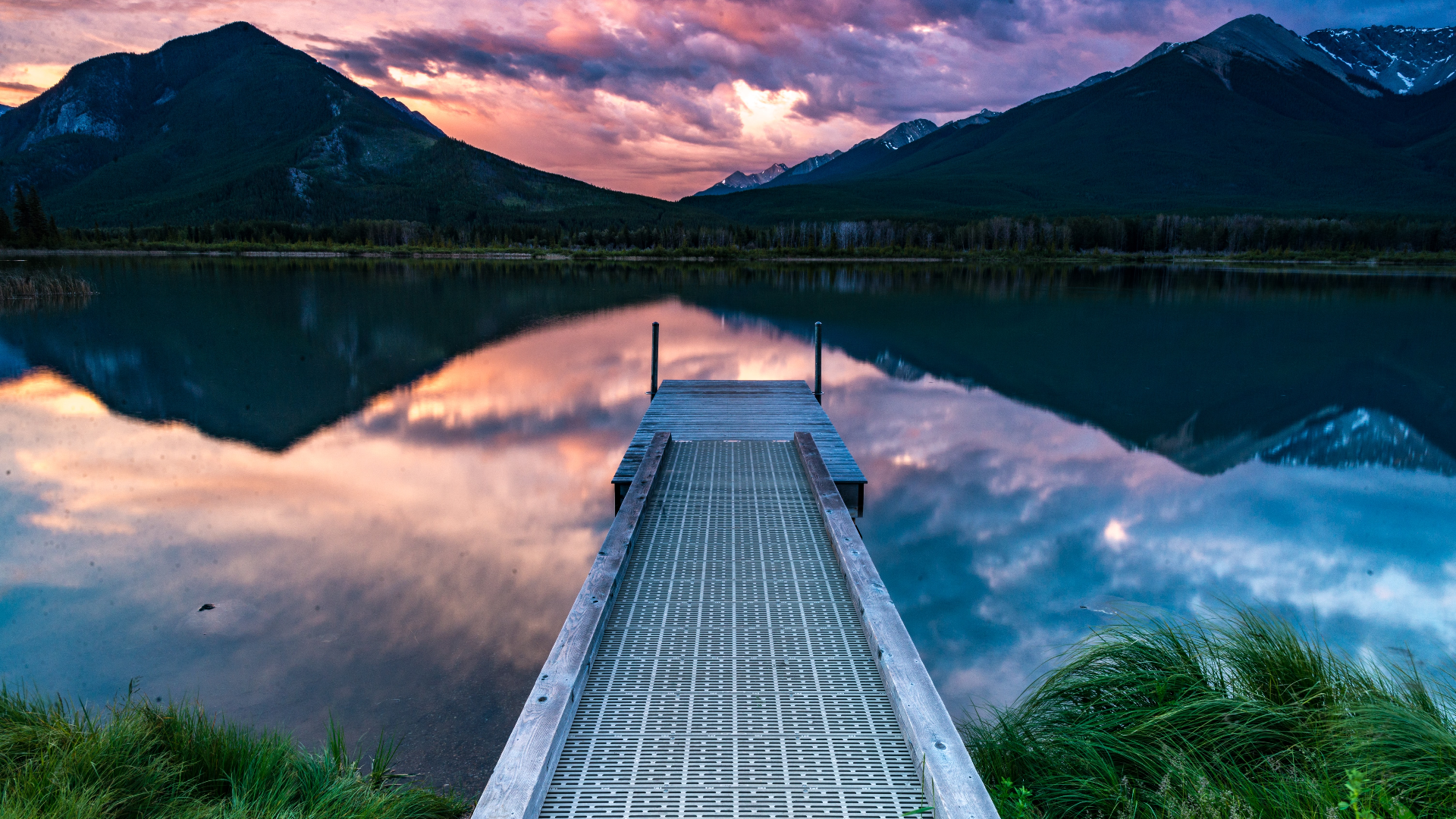 Wooden dock on a lake with mountains at sunset HD Wallpaper