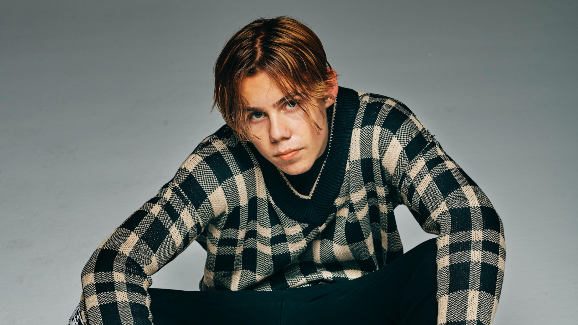 The Kid LAROI in a checkered sweater HD Wallpaper