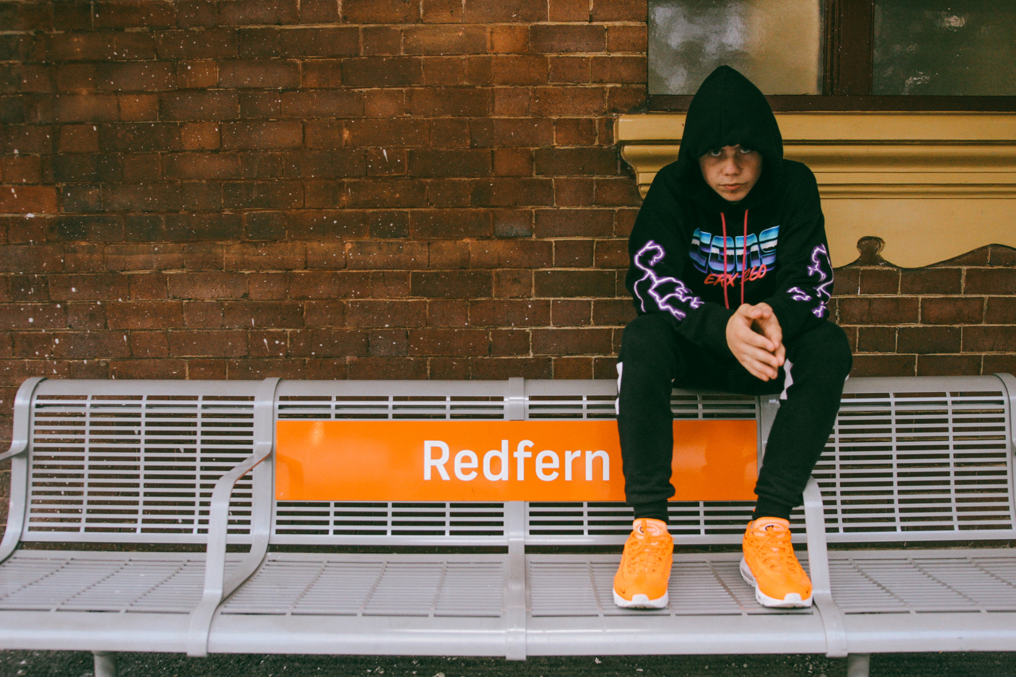 The Kid LAROI sitting on a bench at Redfern station HD Wallpaper