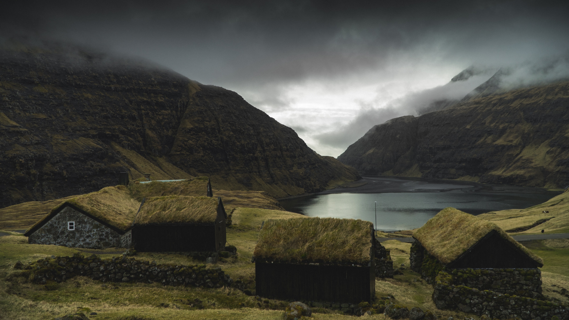 Traditional turf-roofed houses by a lake in the Faroe Islands HD Wallpaper