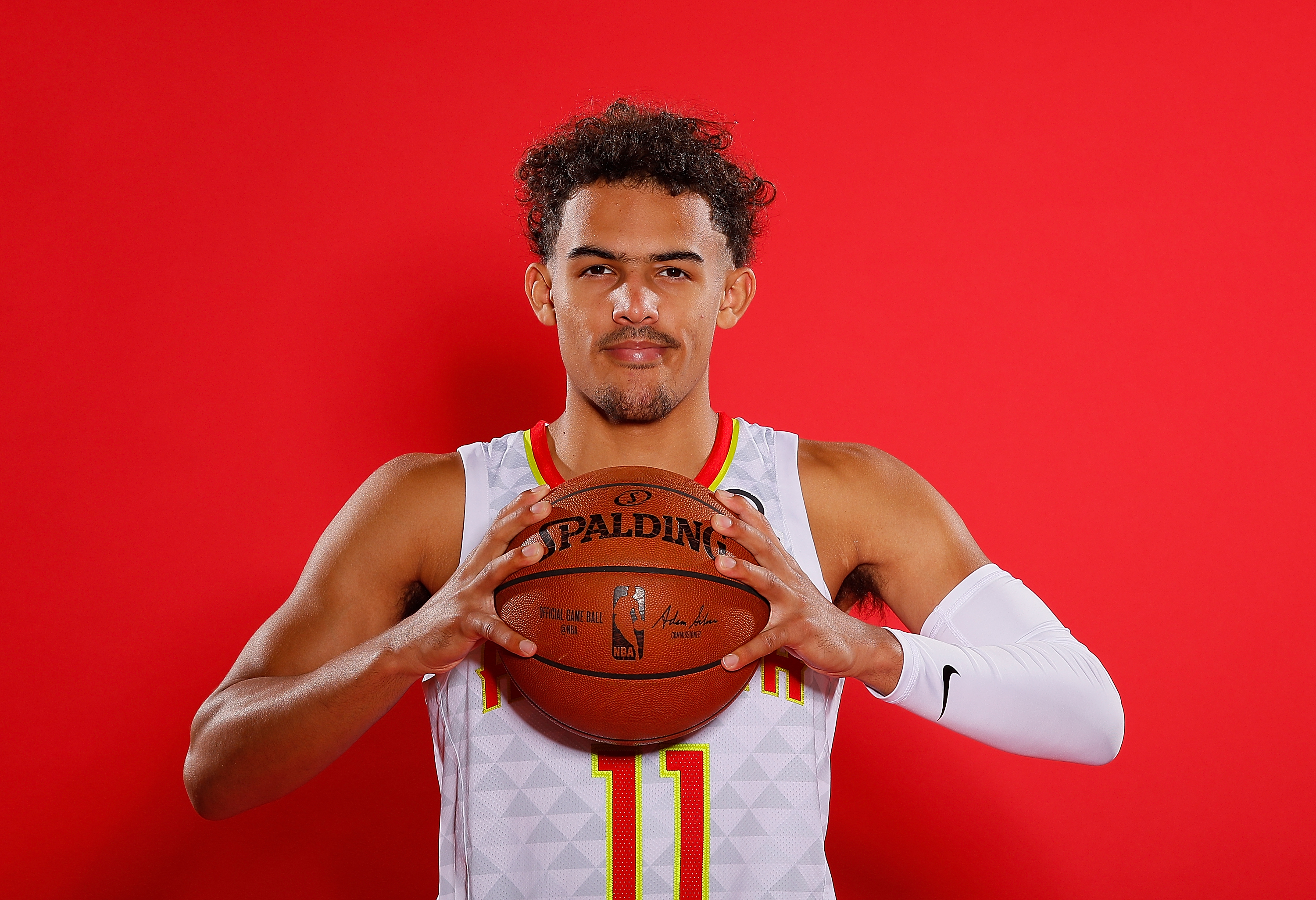 Trae Young holding a Spalding NBA basketball HD Wallpaper