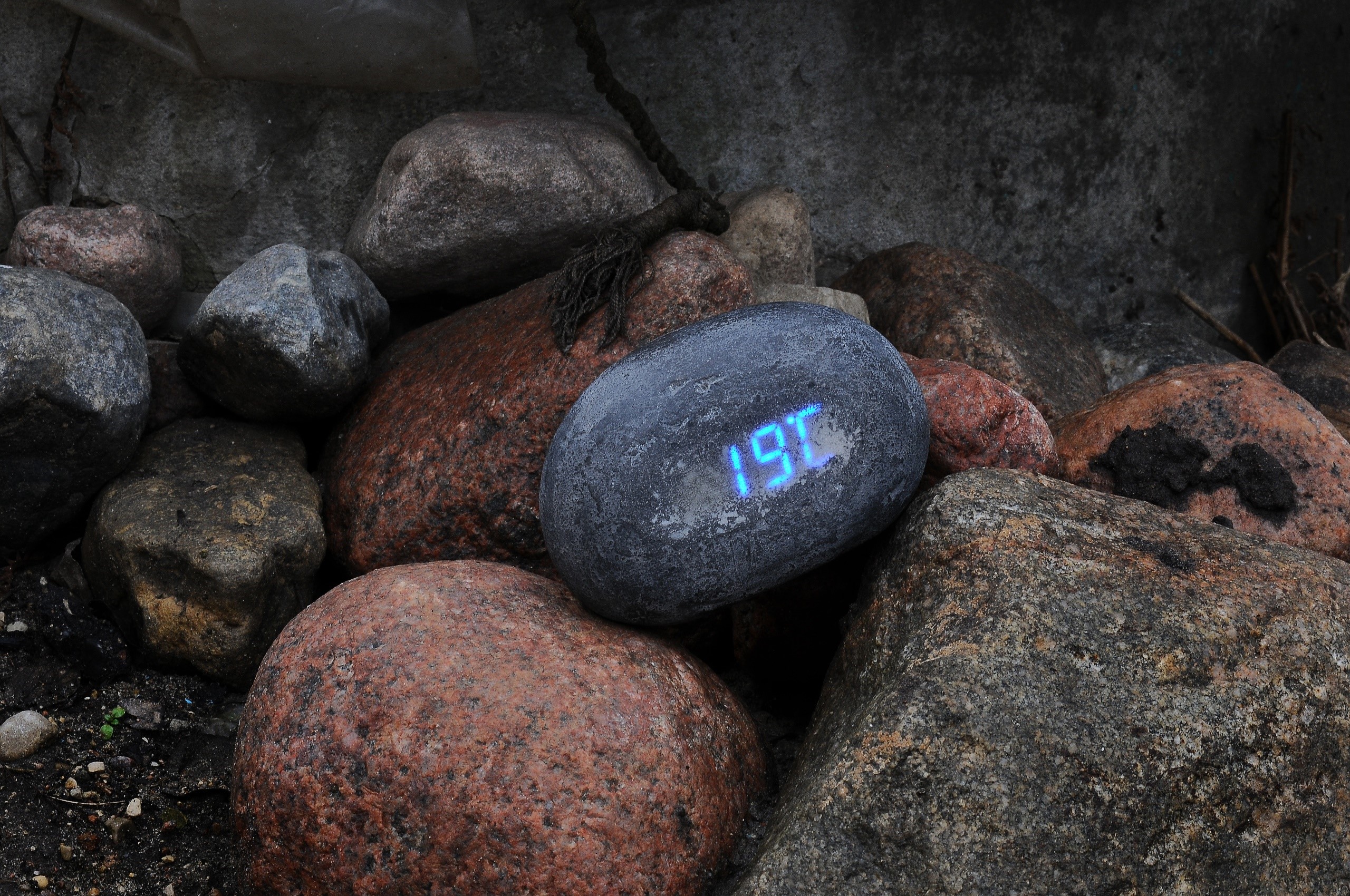 Digital thermometer displaying 19C among stones HD Wallpaper