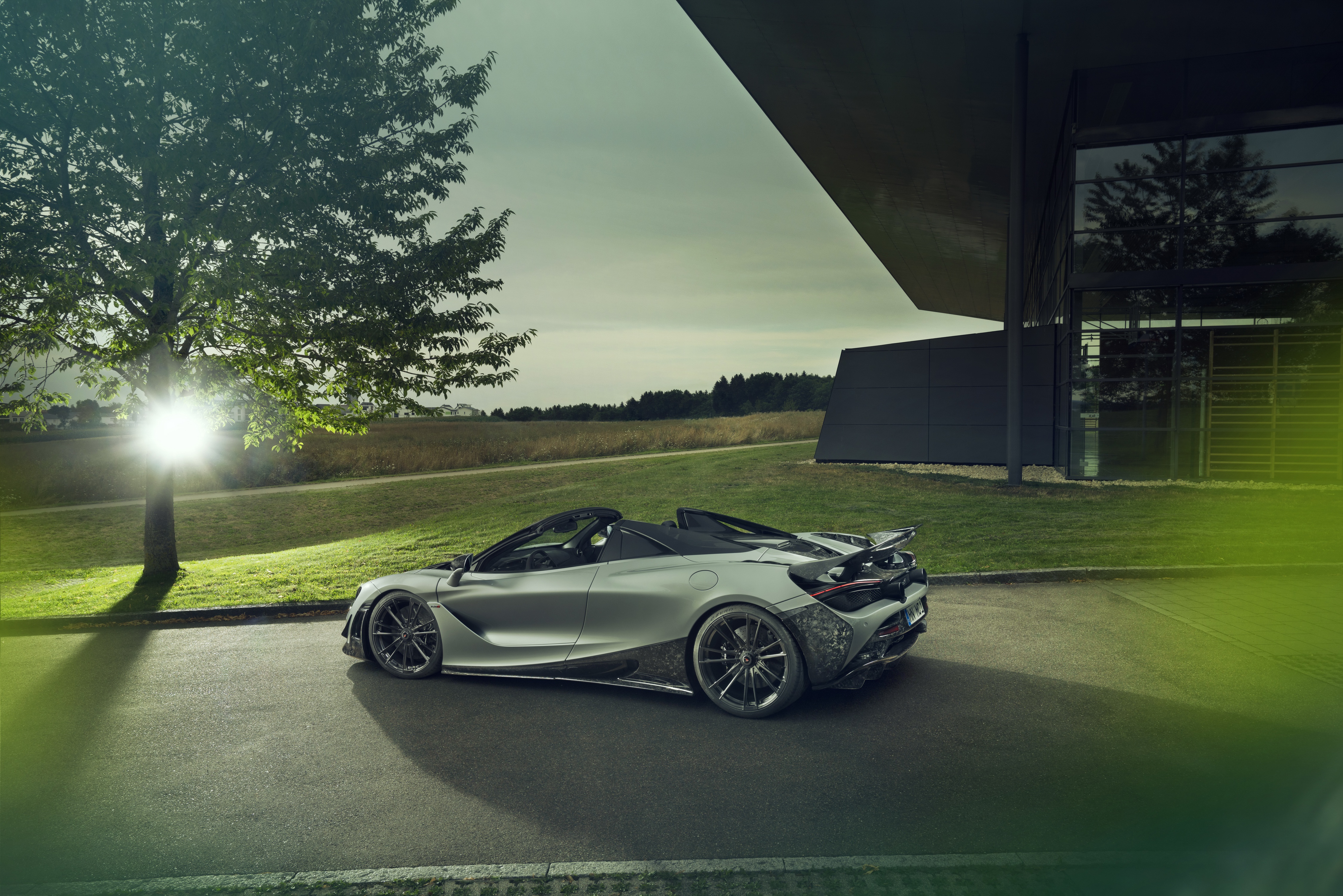 Silver McLaren 720S Spider parked near a modern building HD Wallpaper