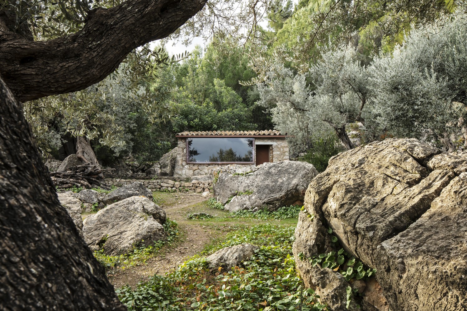 Stone house with large window in a forest HD Wallpaper