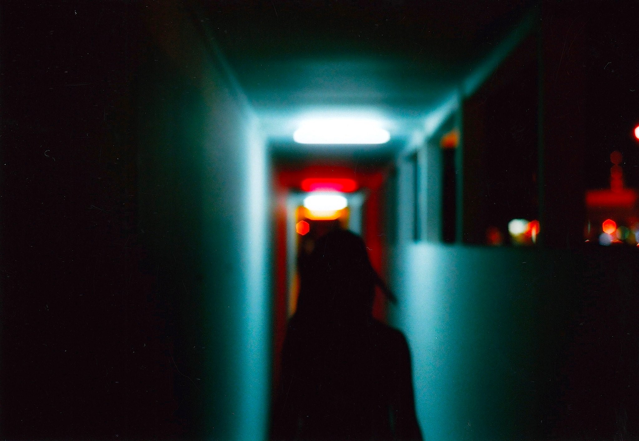 Silhouette of a person in a dark hallway with neon lights HD Wallpaper