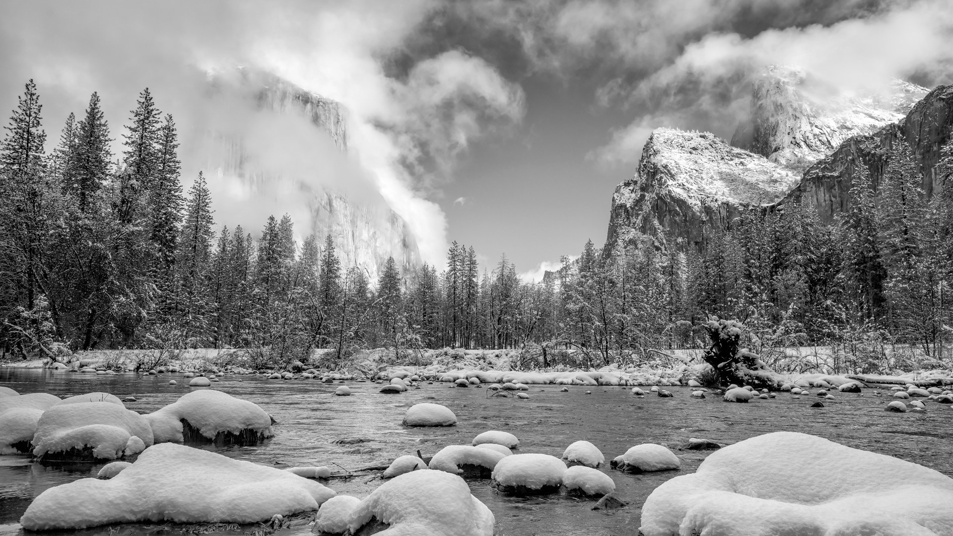 Winter landscape of Yosemite National Park with snow-covered rocks and mountains HD Wallpaper