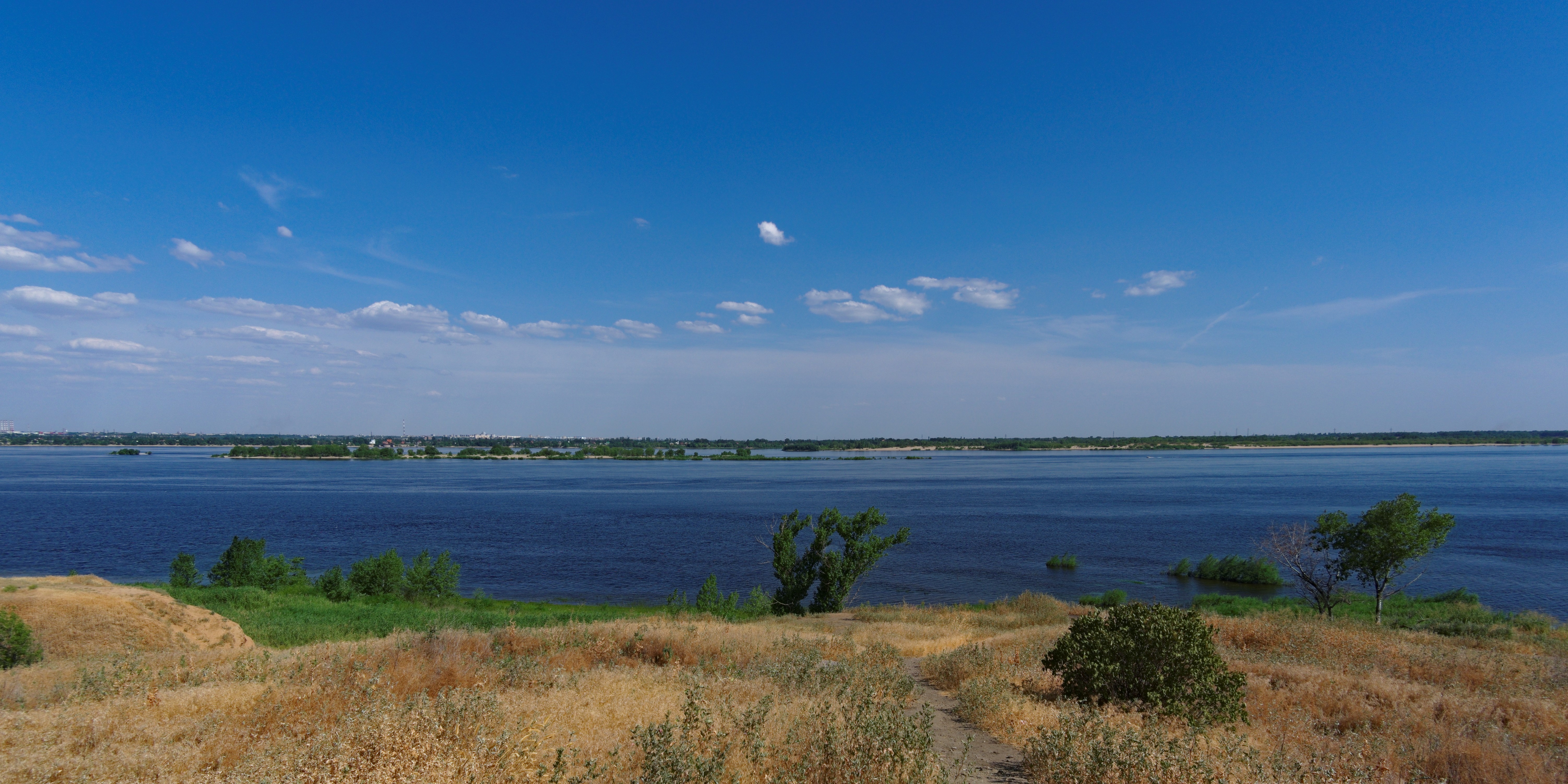 Wide river under a blue sky with clouds HD Wallpaper