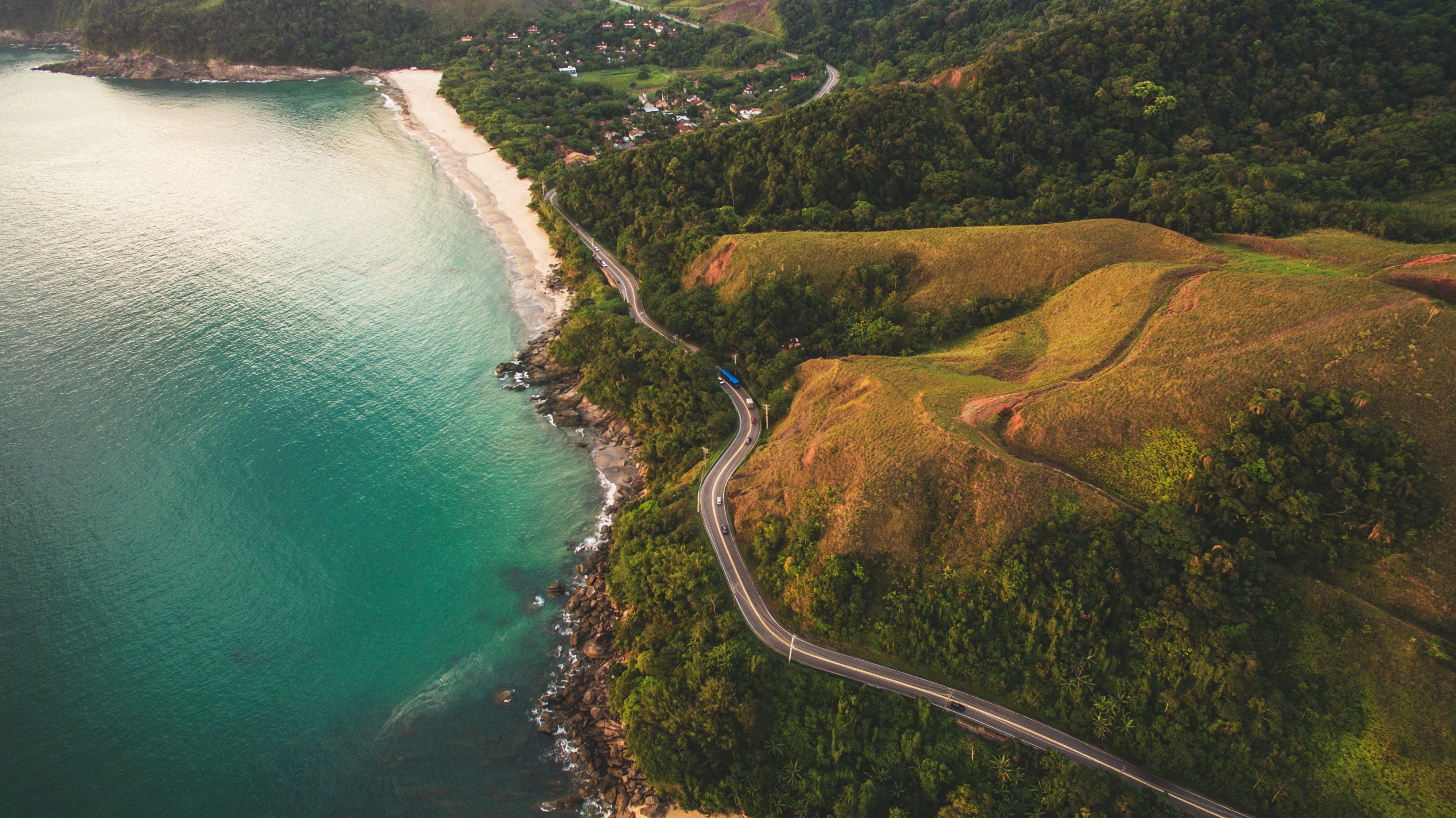 Aerial view of a coastal road in Brazil with hills and beach HD Wallpaper
