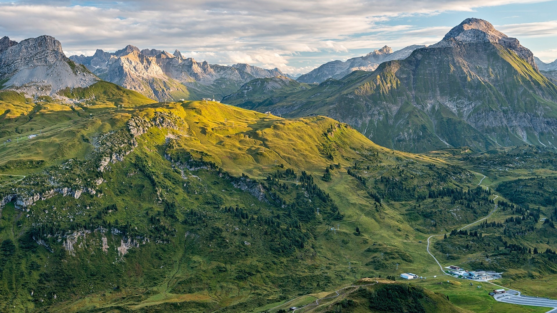 Aerial view of the Alps in Austria with mountains and clouds HD Wallpaper