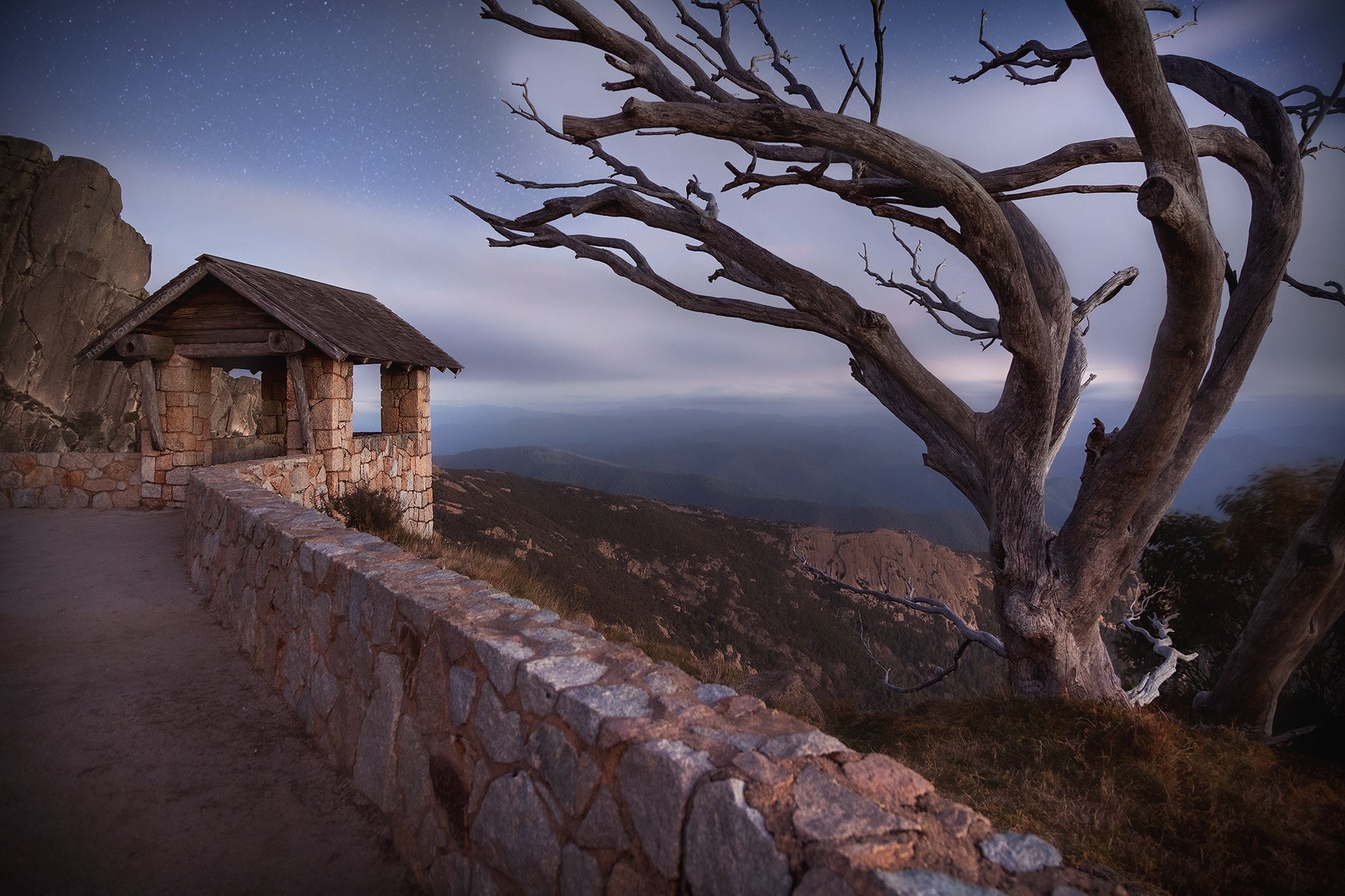Stone shelter and dead tree on Mount Buffalo, Australia HD Wallpaper