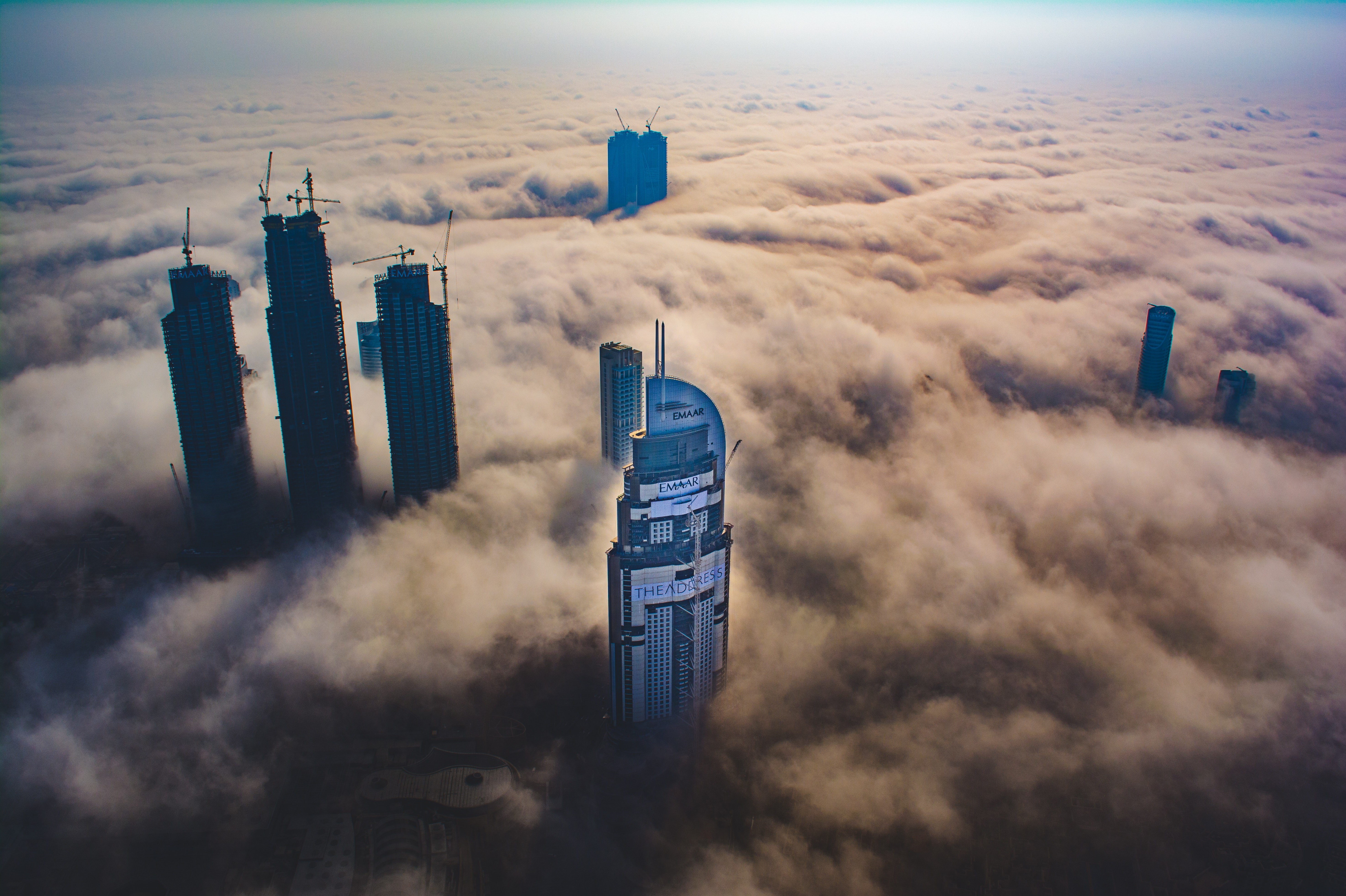 Futuristic city skyscrapers emerging from clouds HD Wallpaper