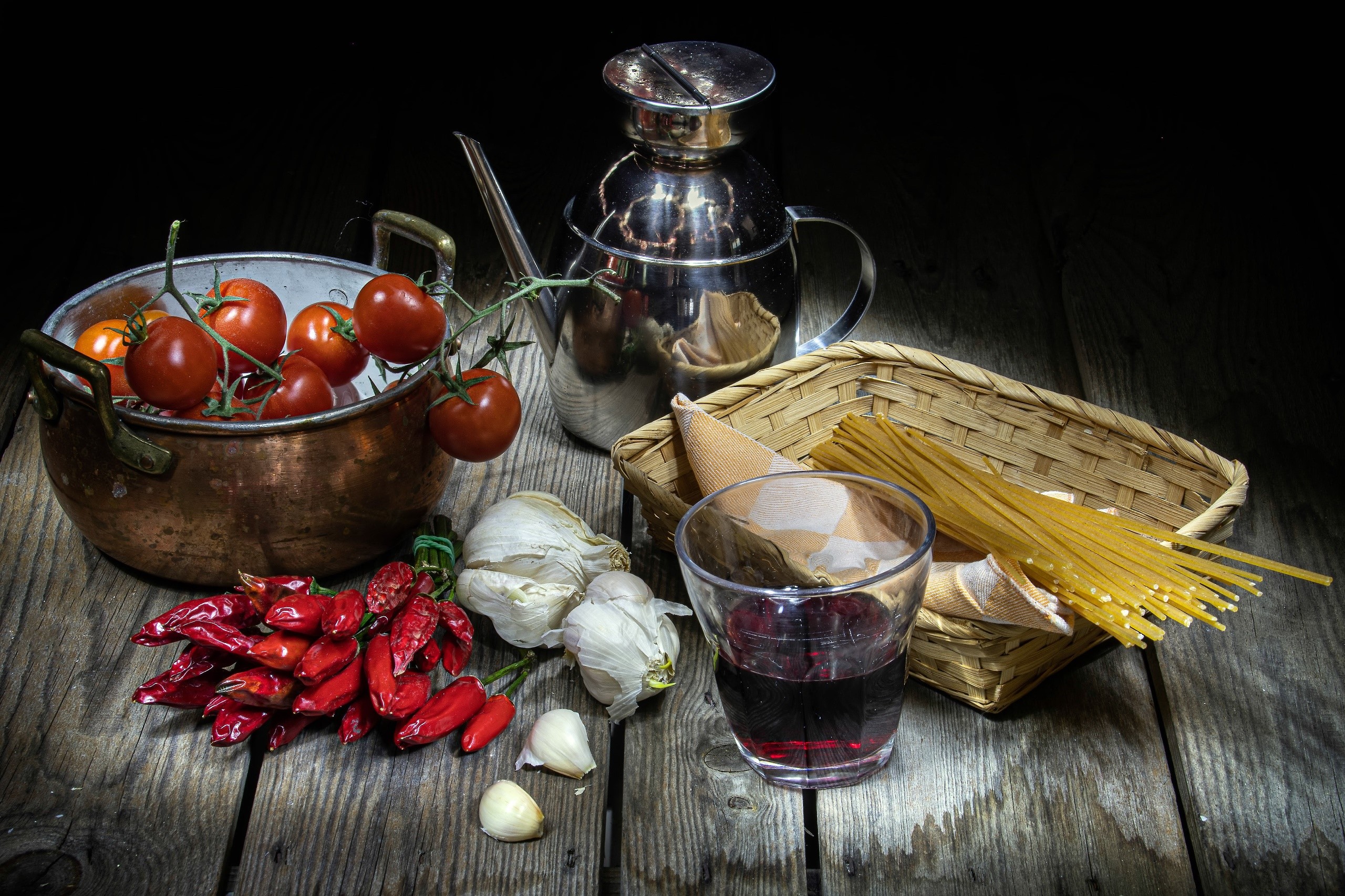 Still life of tomatoes, peppers, garlic, spaghetti, and wine HD Wallpaper