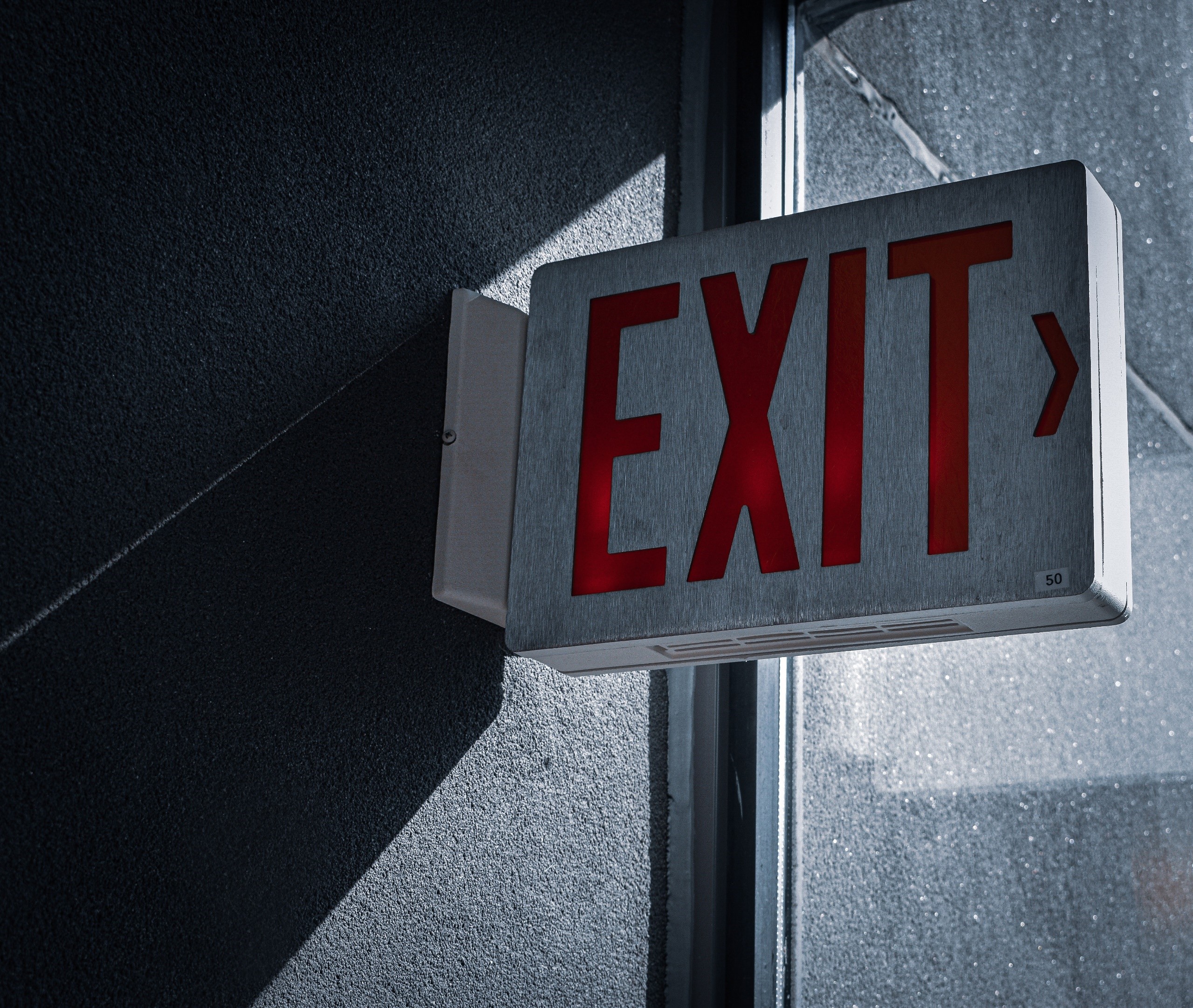 Red illuminated EXIT sign on a dark wall HD Wallpaper