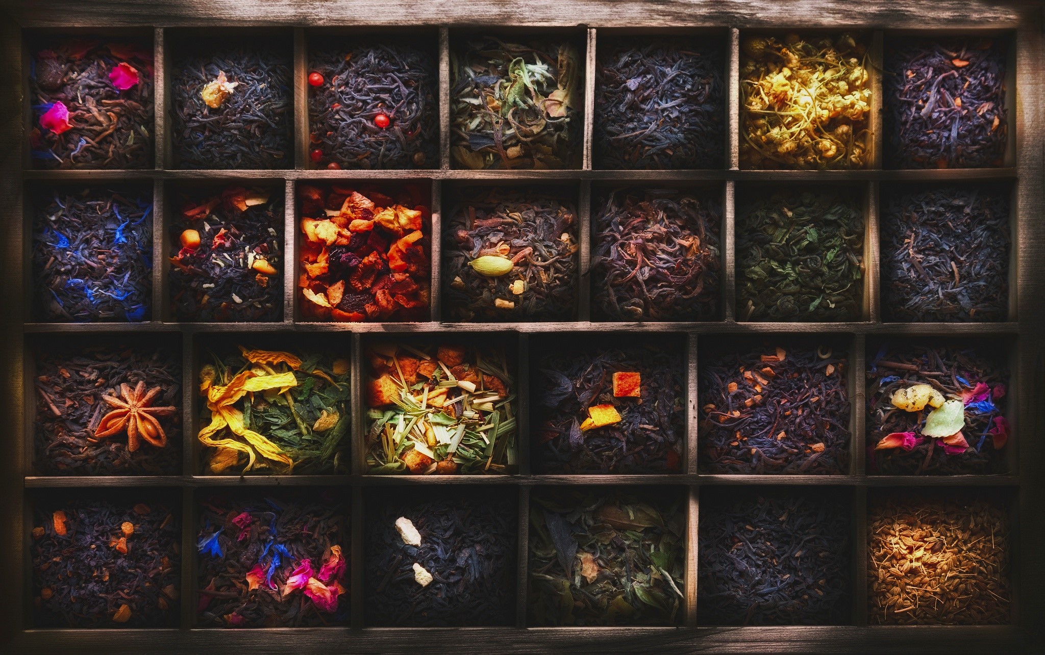 Assortment of loose leaf teas in wooden compartments HD Wallpaper