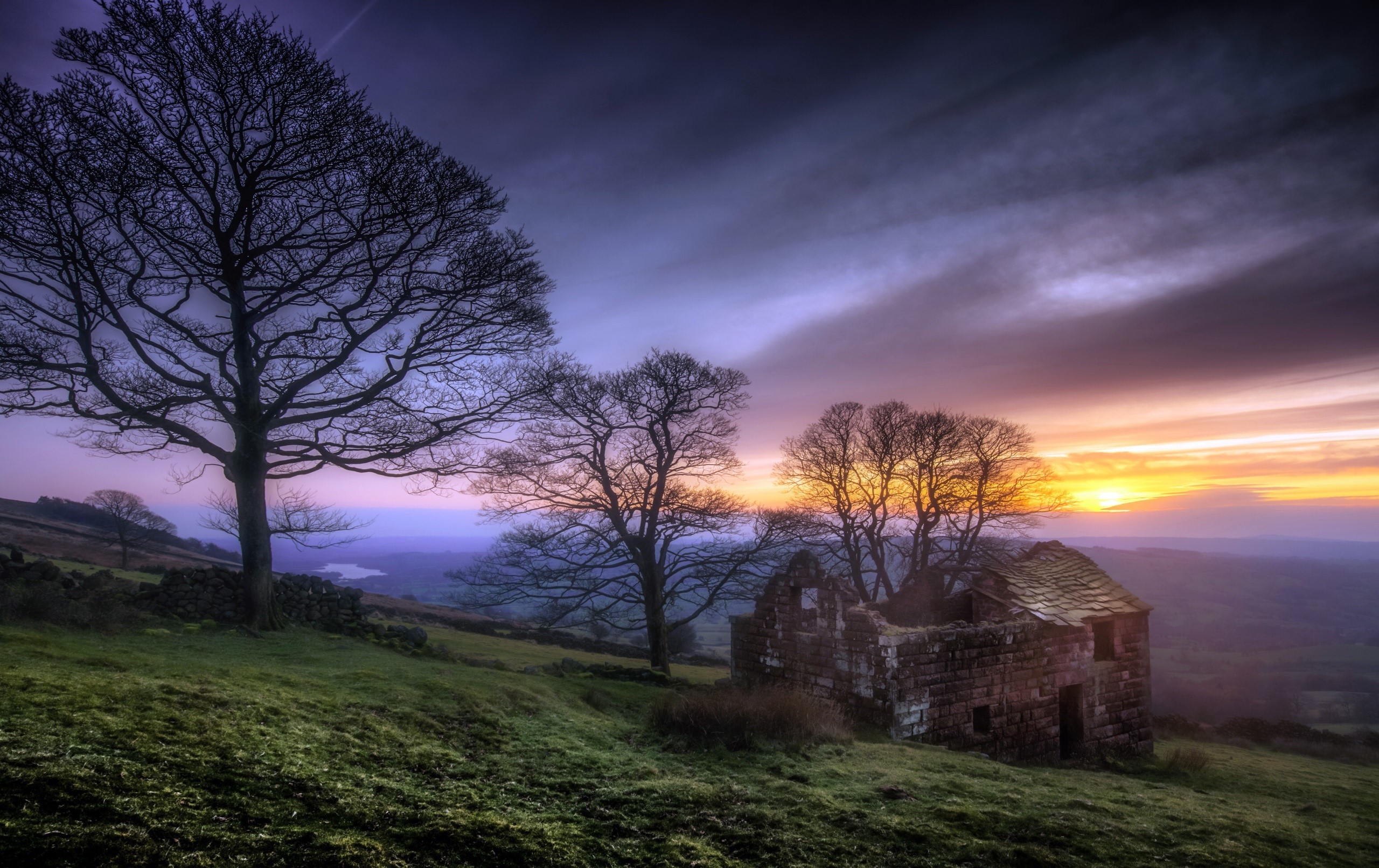 Ruin and trees at sunset over a valley HD Wallpaper