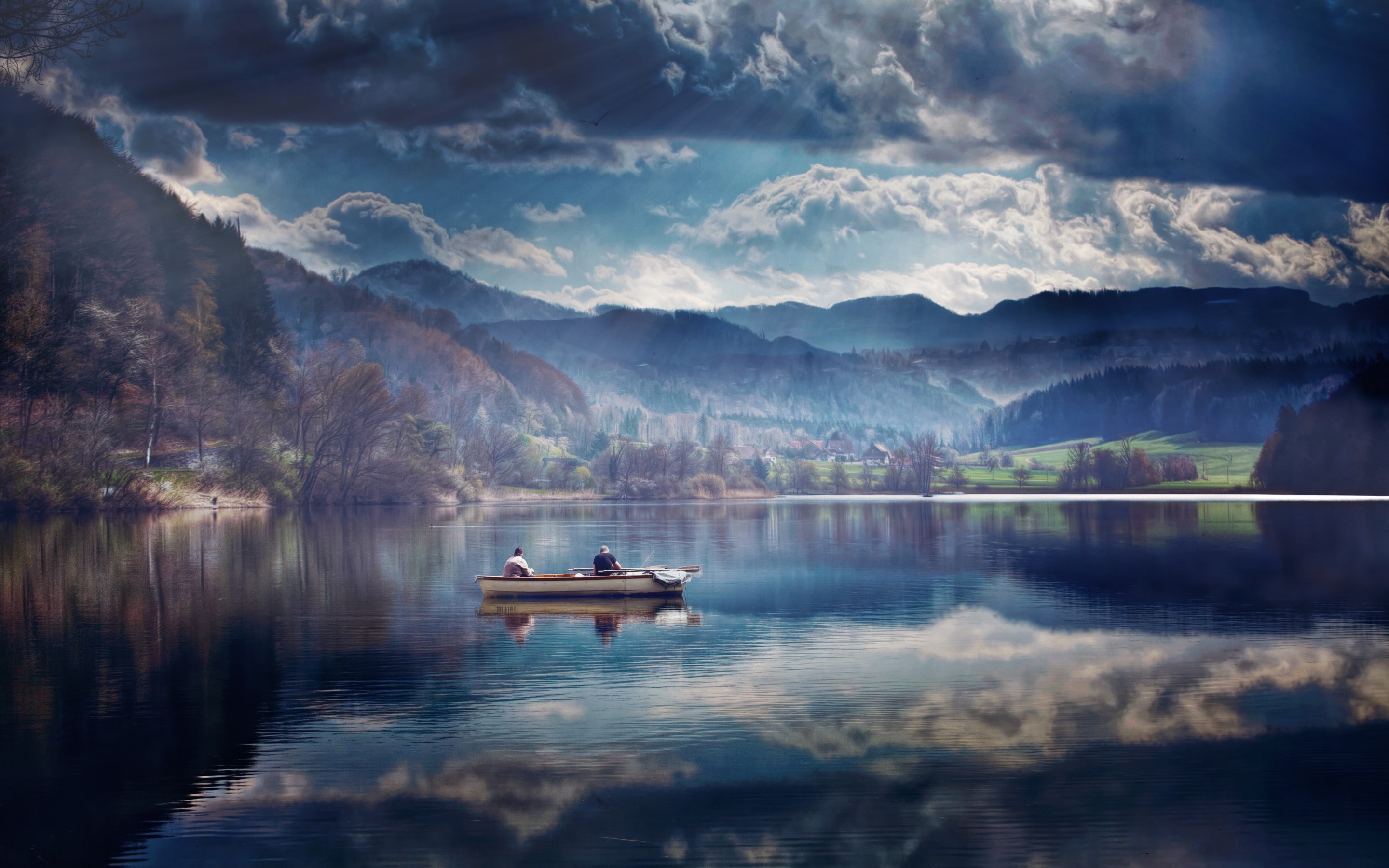Two people in a boat on a lake with mountains and clouds HD Wallpaper