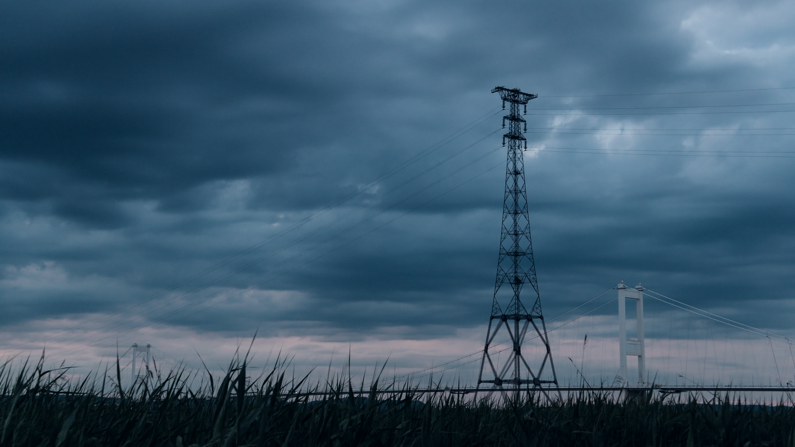 Power lines and bridge under cloudy sky HD Wallpaper