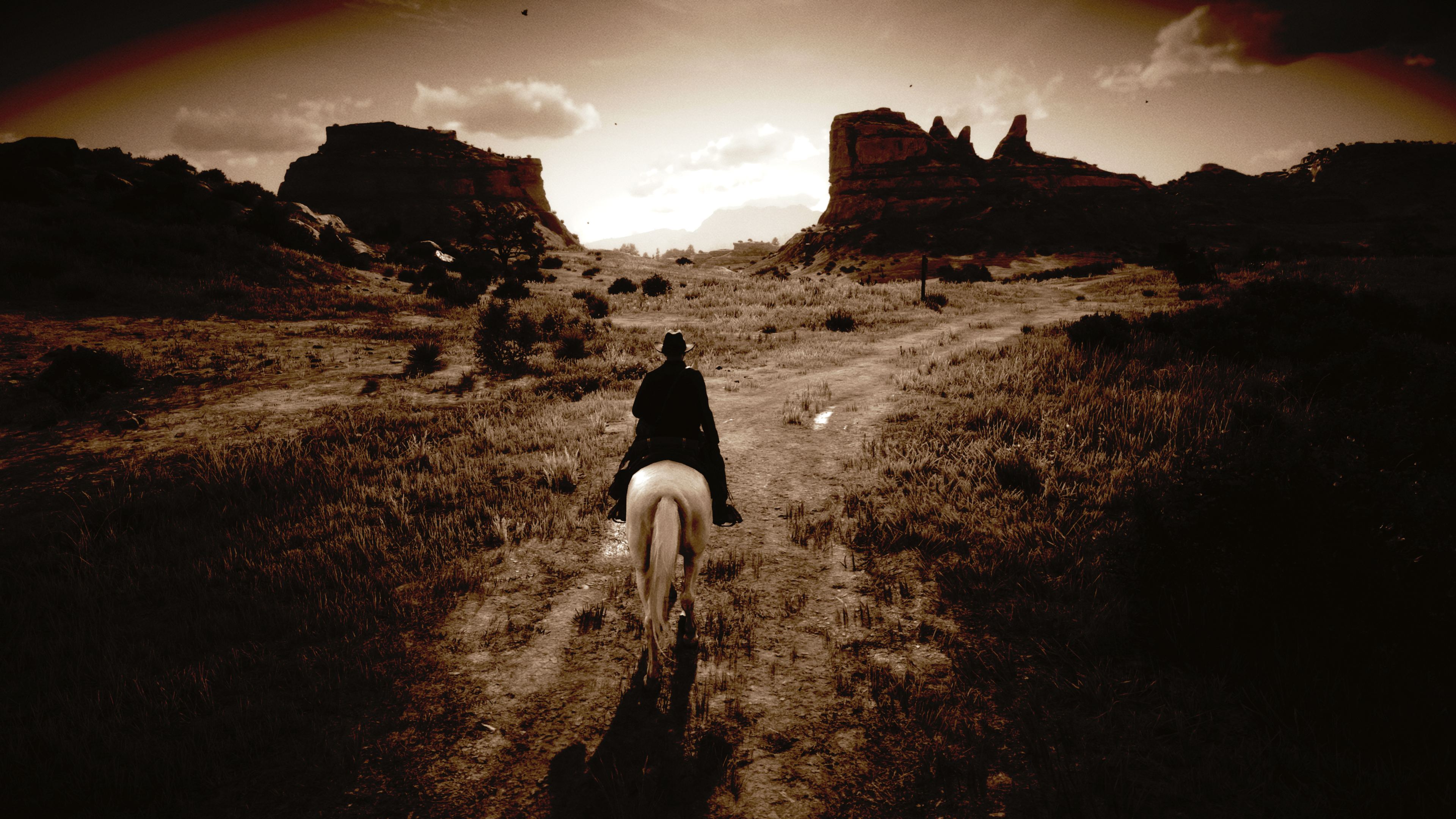 Arthur Morgan rides a horse through a desert landscape HD Wallpaper