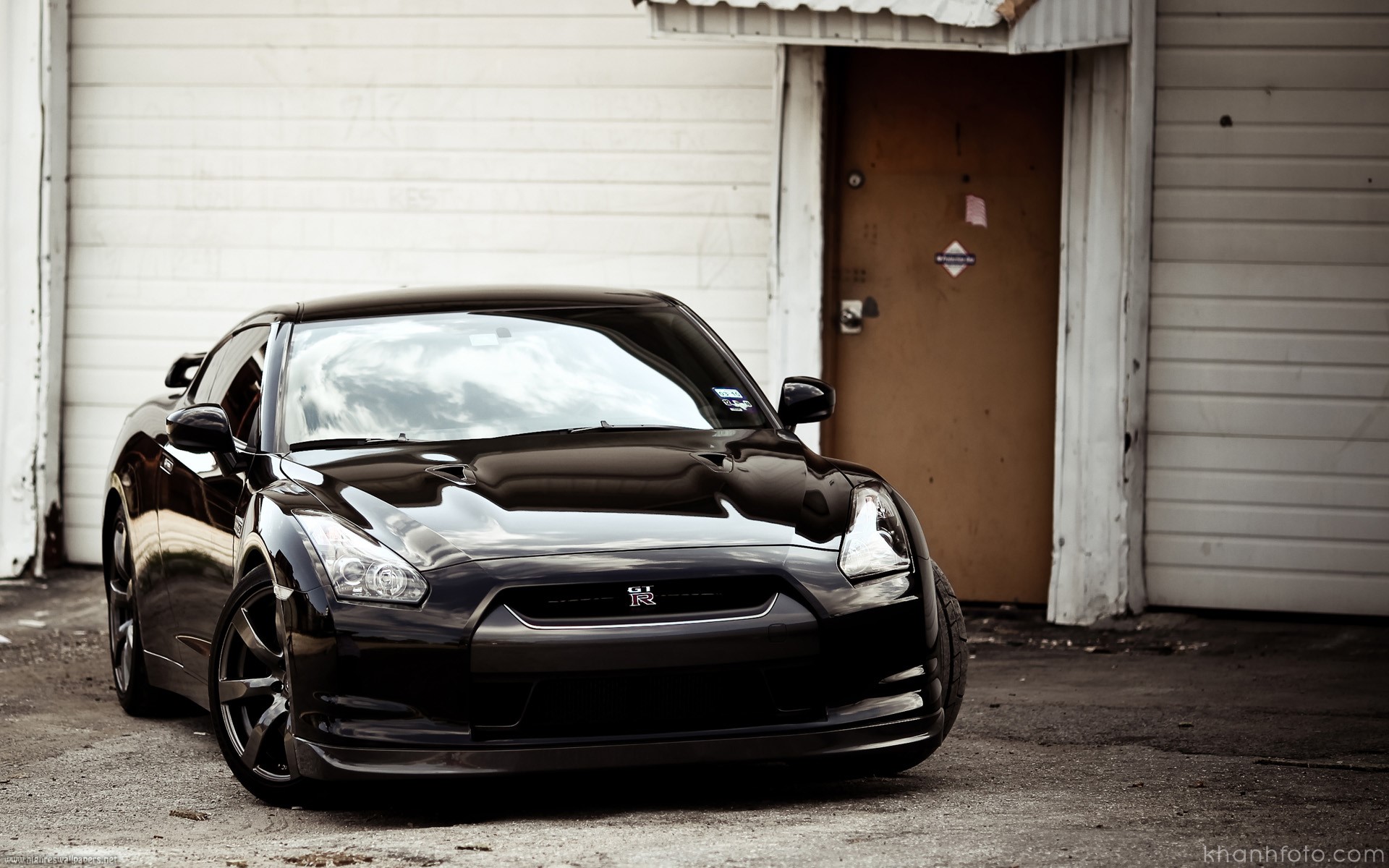 Black Nissan GT-R parked outside a building HD Wallpaper