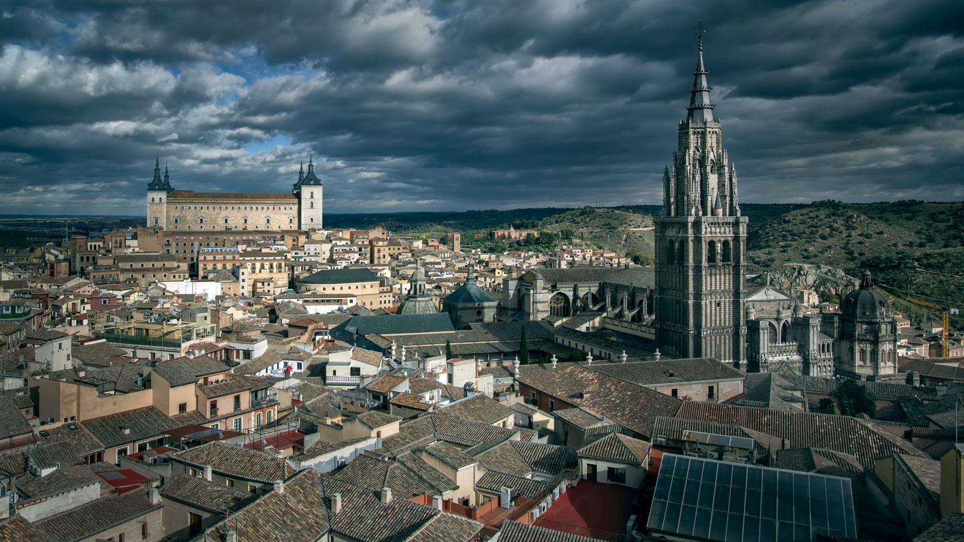 Toledo cityscape with cathedral and castle under cloudy sky HD Wallpaper