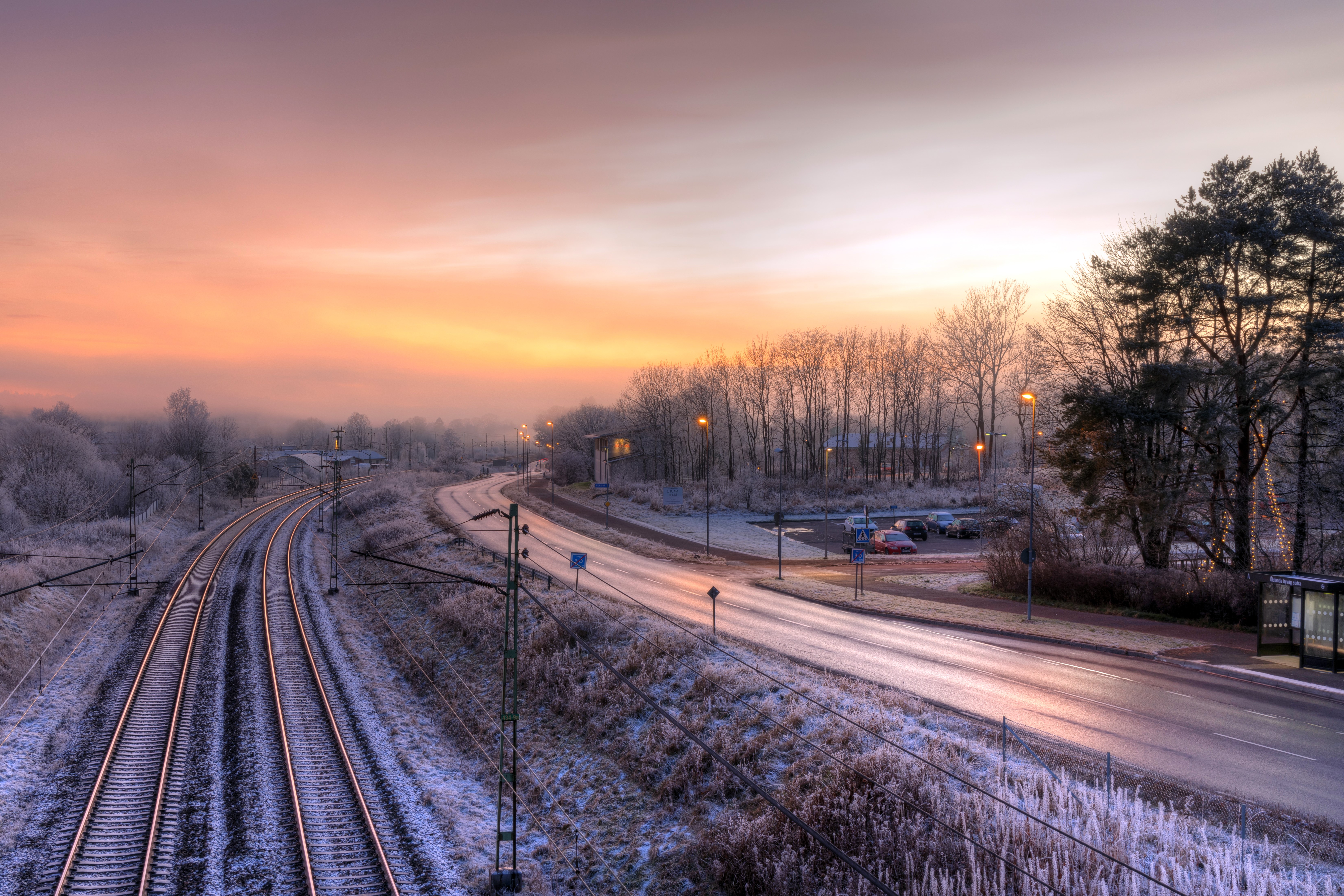 Winter sunset over railroad tracks and road HD Wallpaper