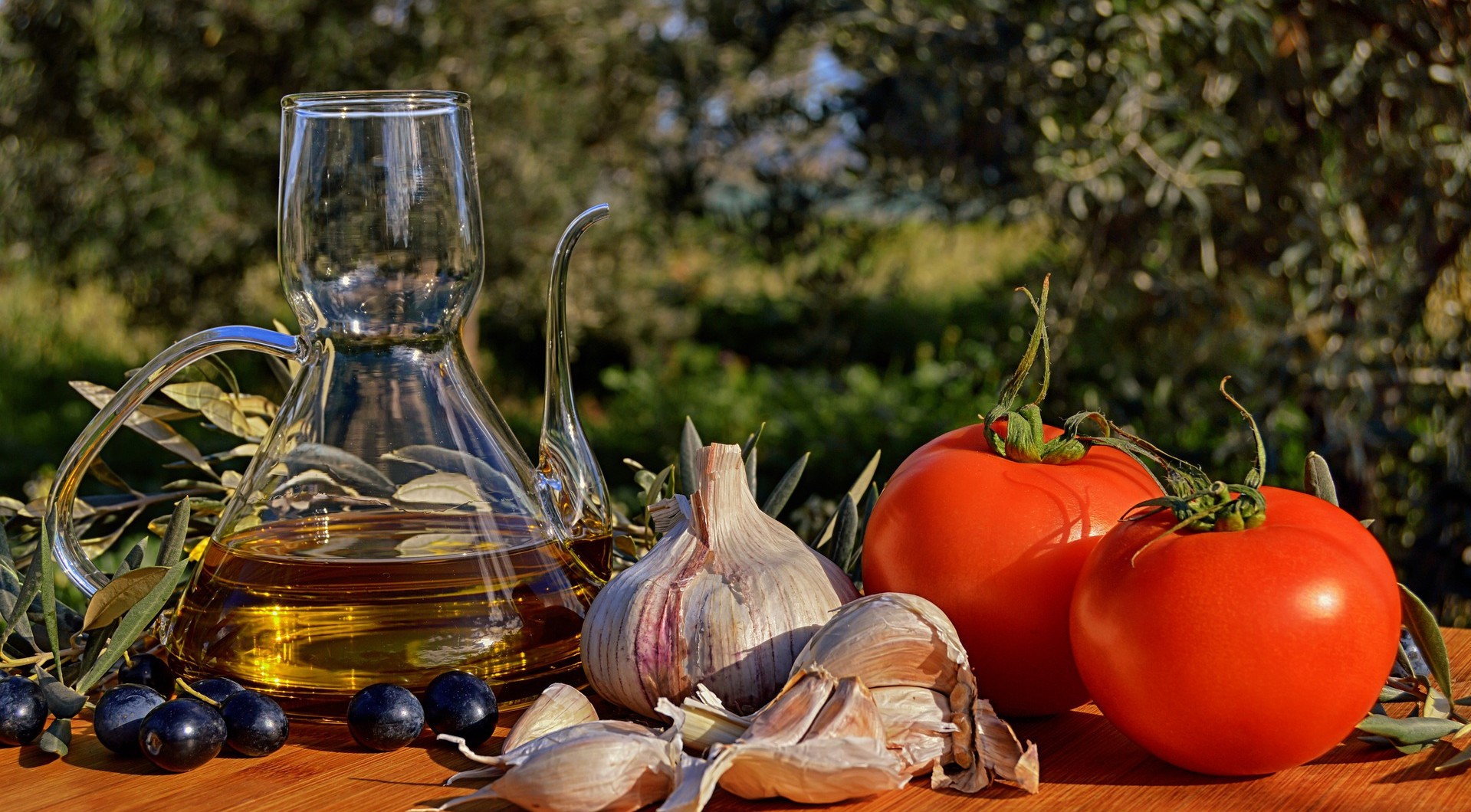 Tomatoes, garlic, olives, and olive oil on a wooden table HD Wallpaper