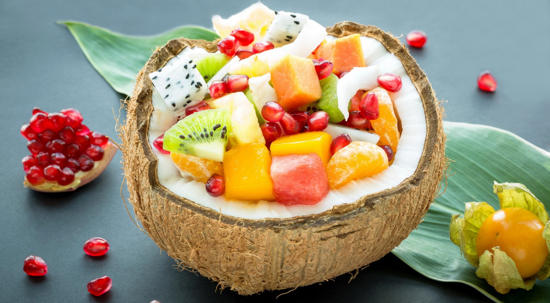 Fruit salad in a coconut bowl with pomegranate and physalis HD Wallpaper