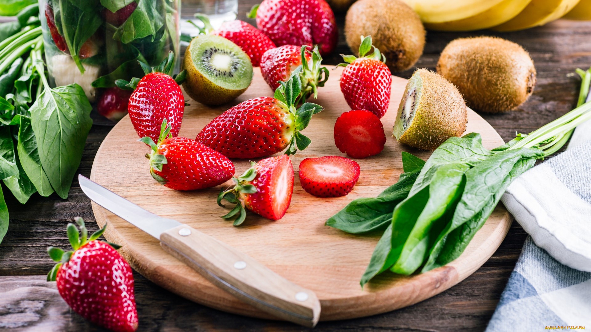 Strawberries, kiwis, bananas, and spinach on a cutting board HD Wallpaper