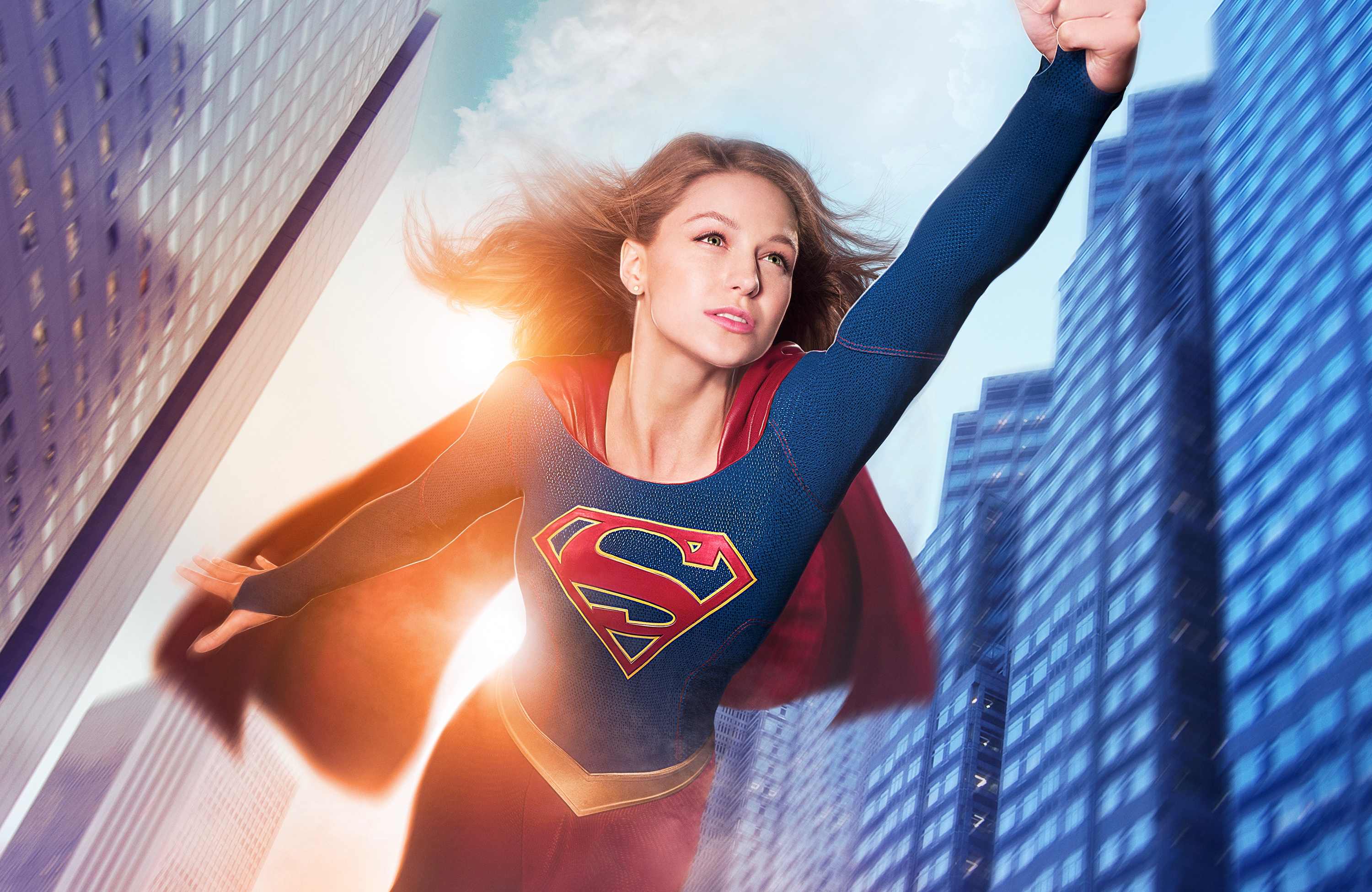 Supergirl flying between skyscrapers HD Wallpaper