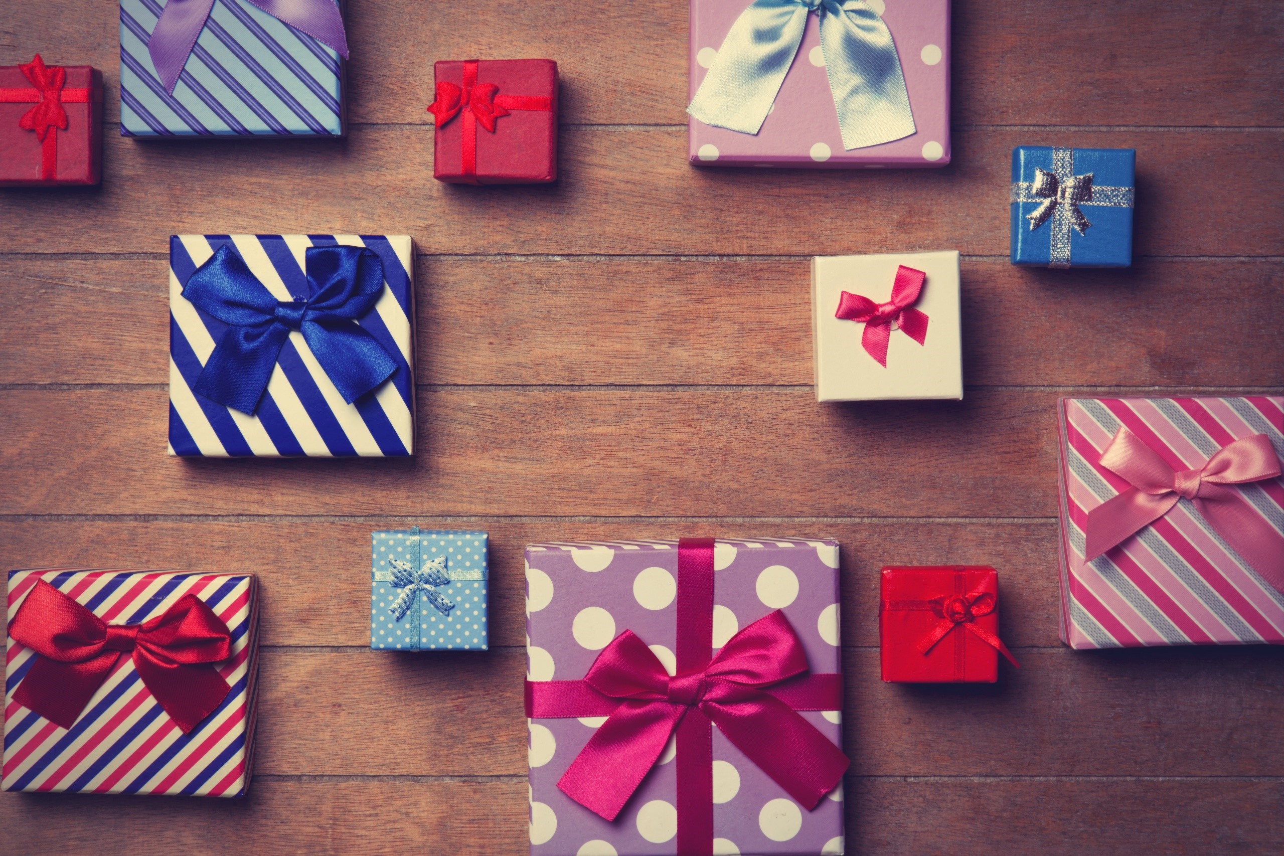 Colorful gift boxes with ribbons on a wooden surface HD Wallpaper