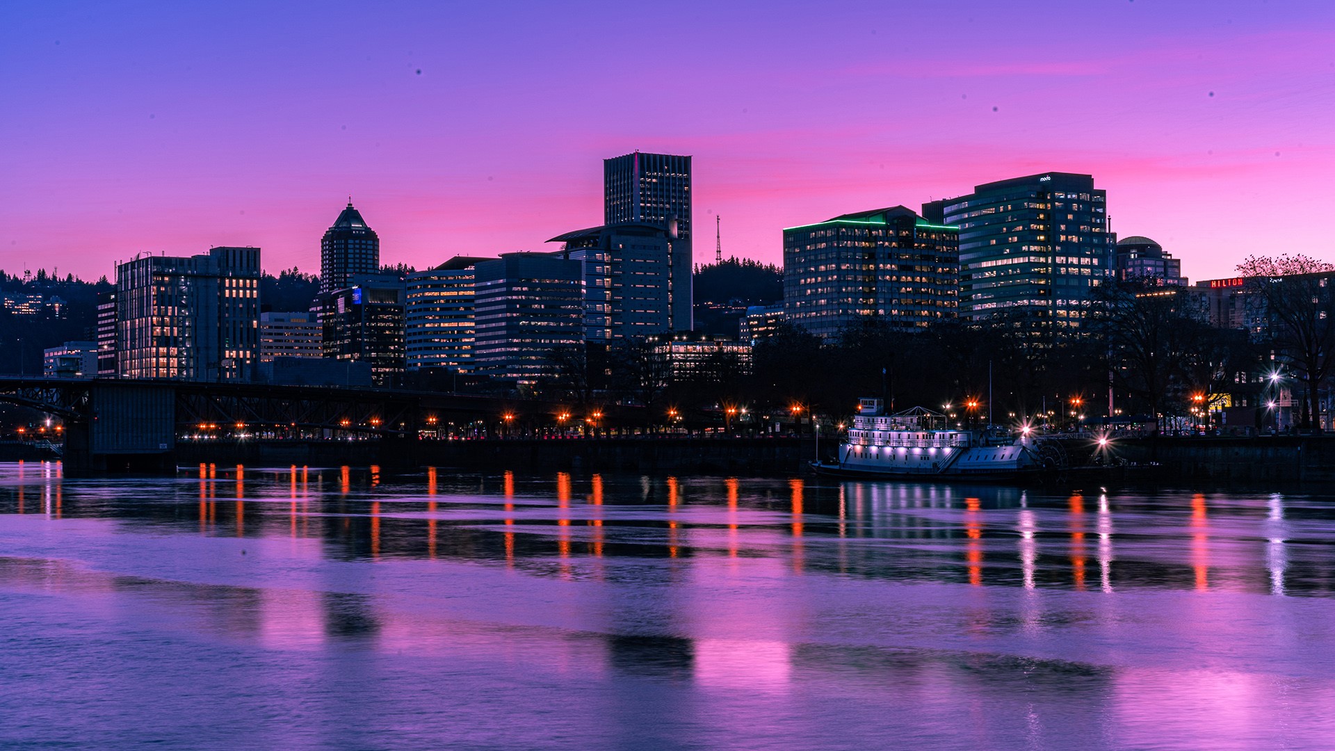 City skyline reflected in water at sunset HD Wallpaper