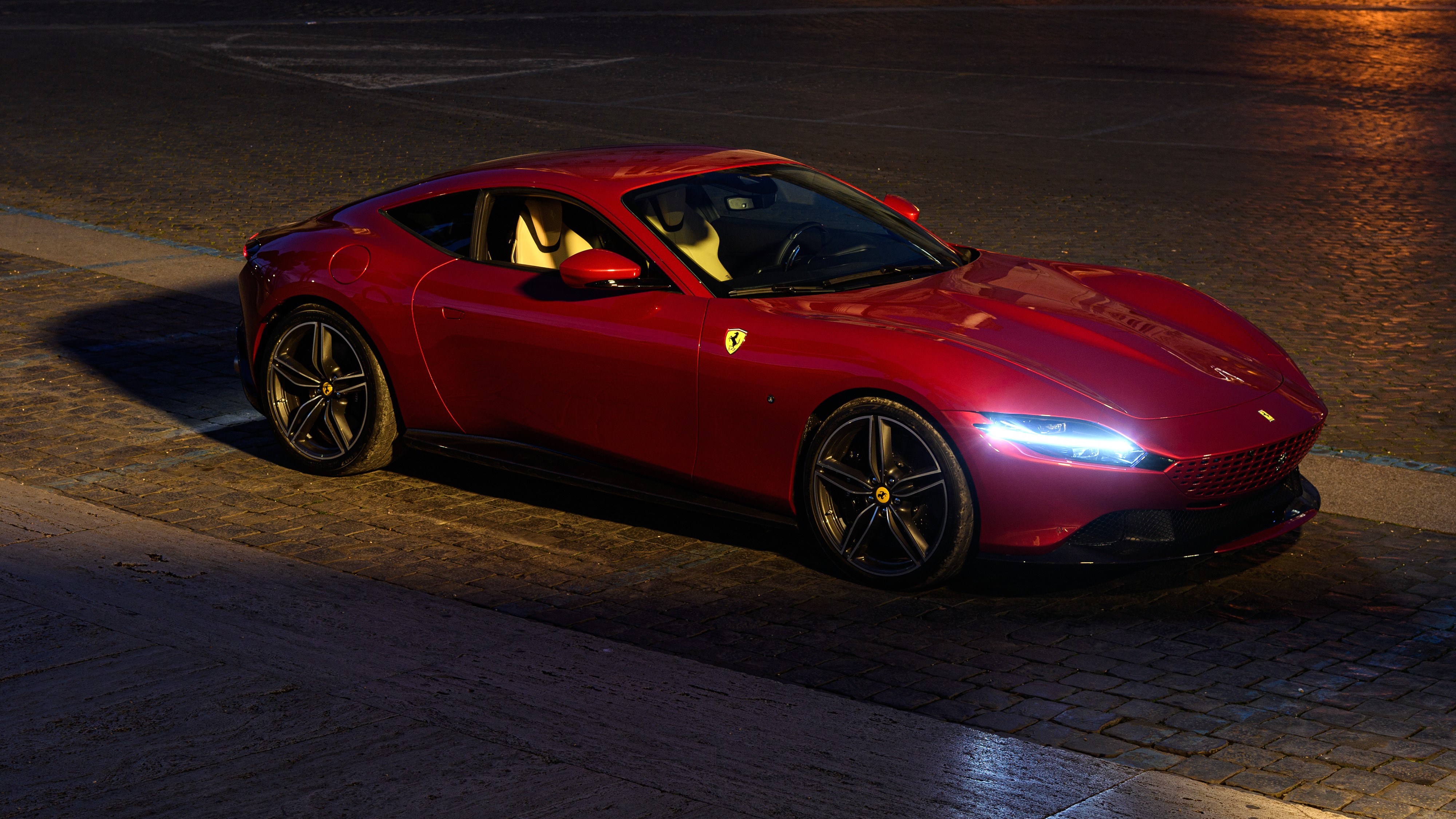 Ferrari Roma parked on a cobblestone street at night HD Wallpaper