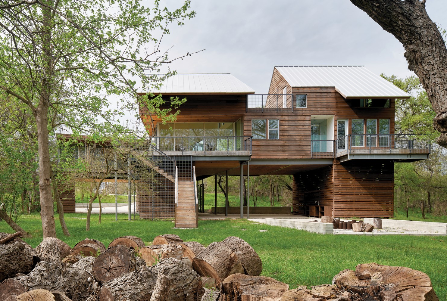 Modern wooden house on stilts in a forest HD Wallpaper