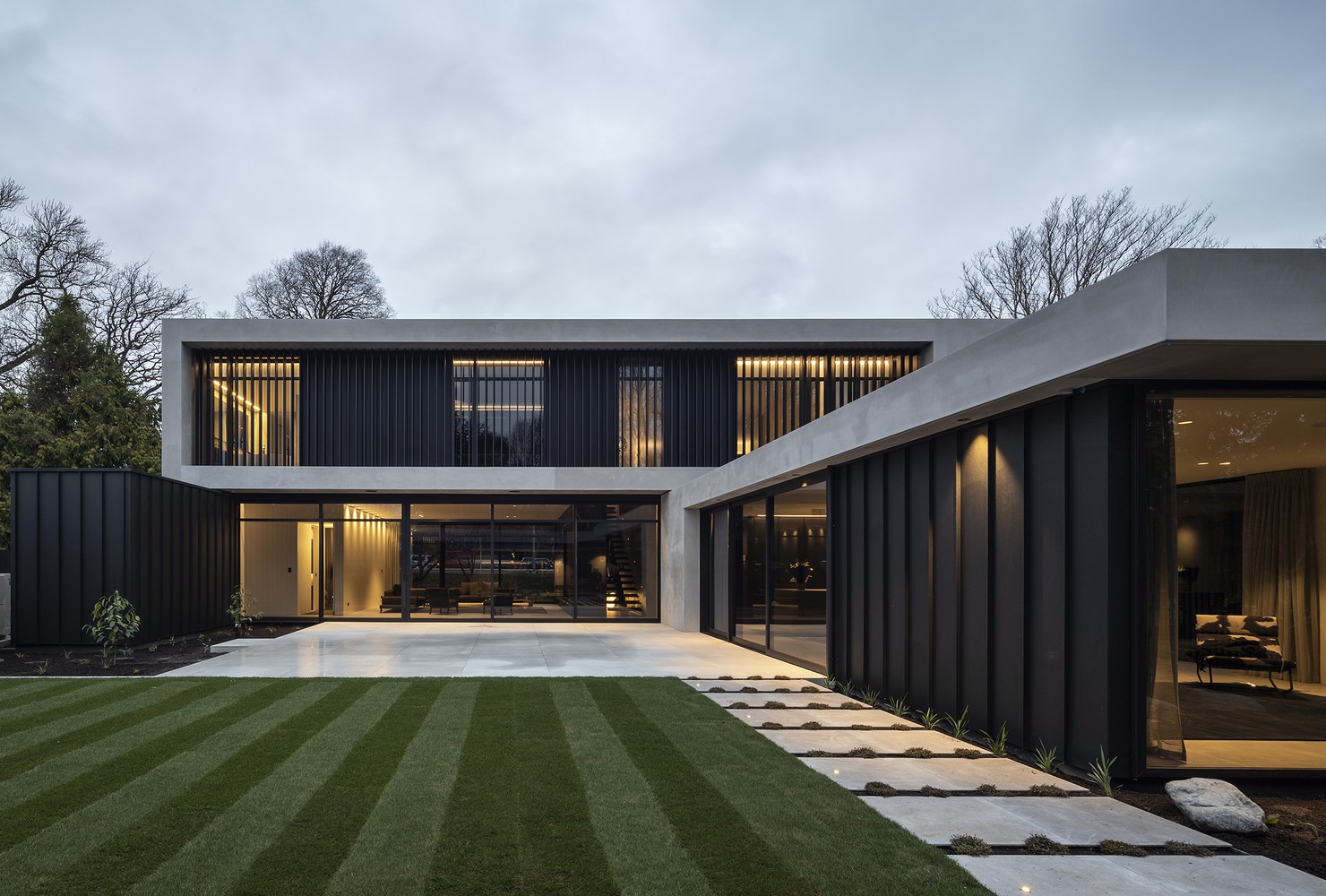 Modern concrete and black metal house with lawn HD Wallpaper