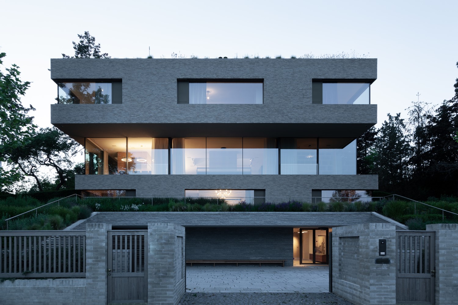 Modern brick house with large windows and green roof HD Wallpaper