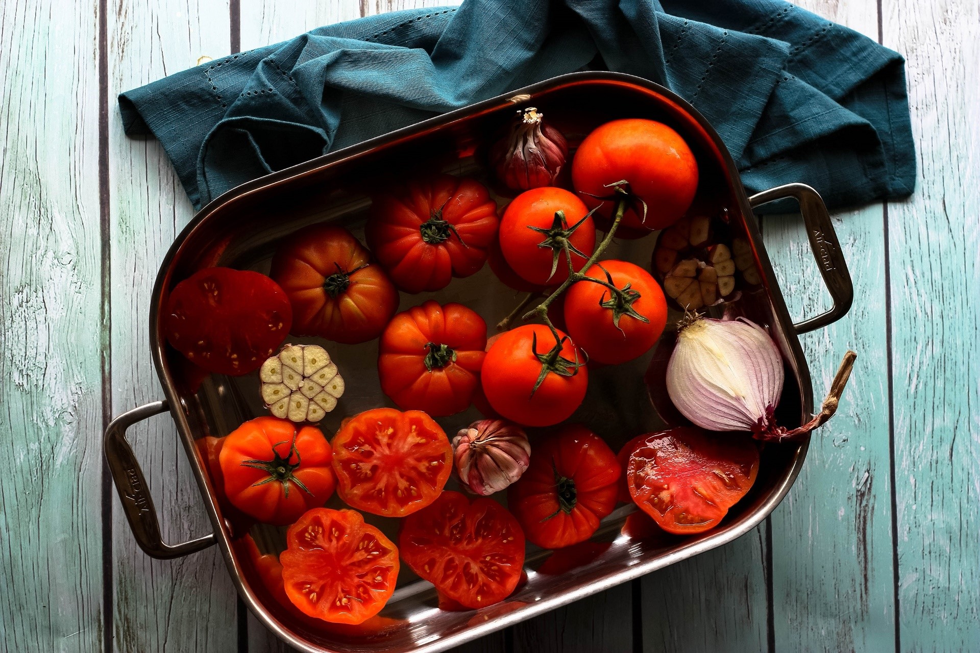 Tomatoes, garlic, and red onion in a roasting pan HD Wallpaper