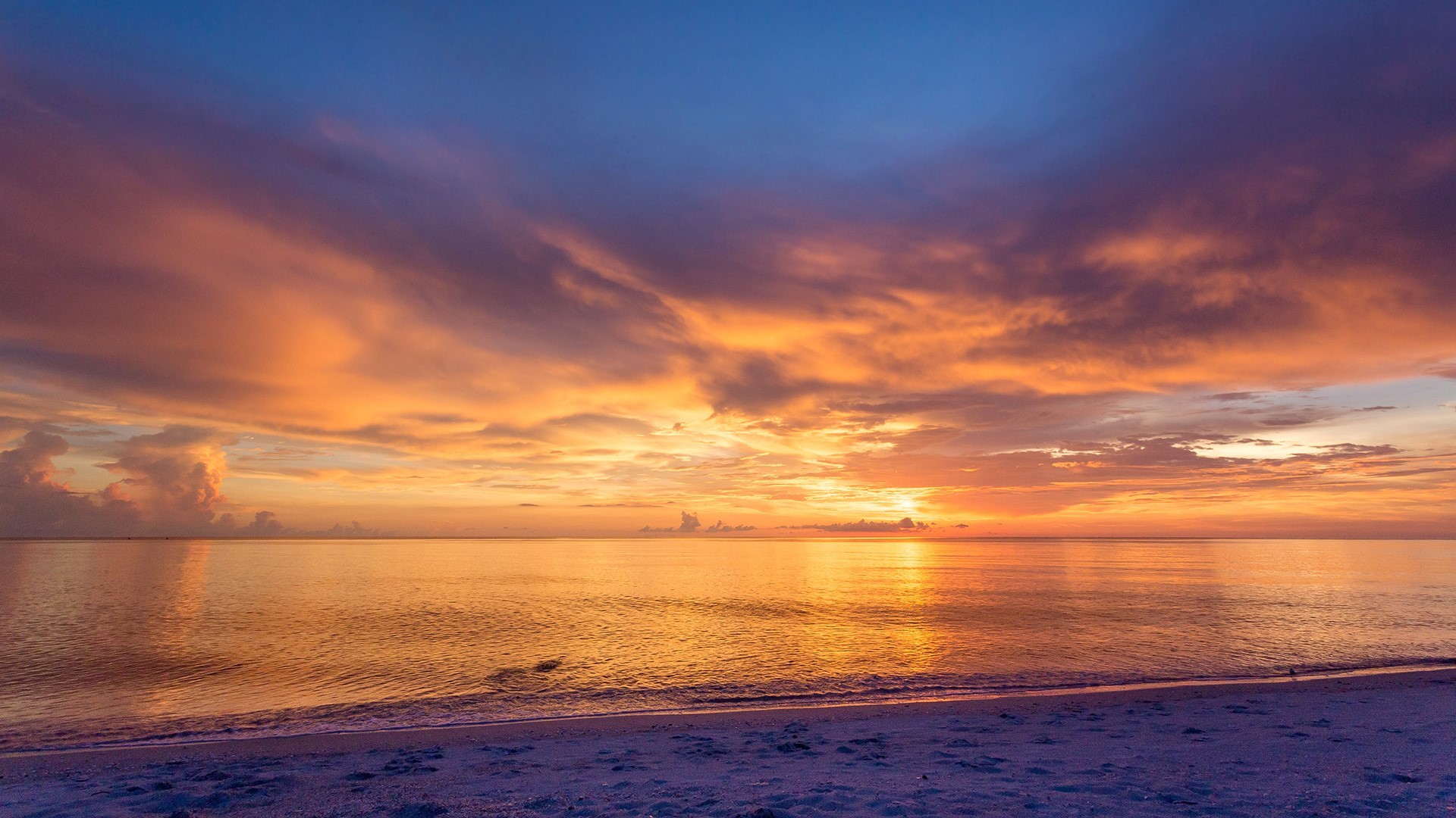 Sunset over the ocean with colorful clouds and beach HD Wallpaper