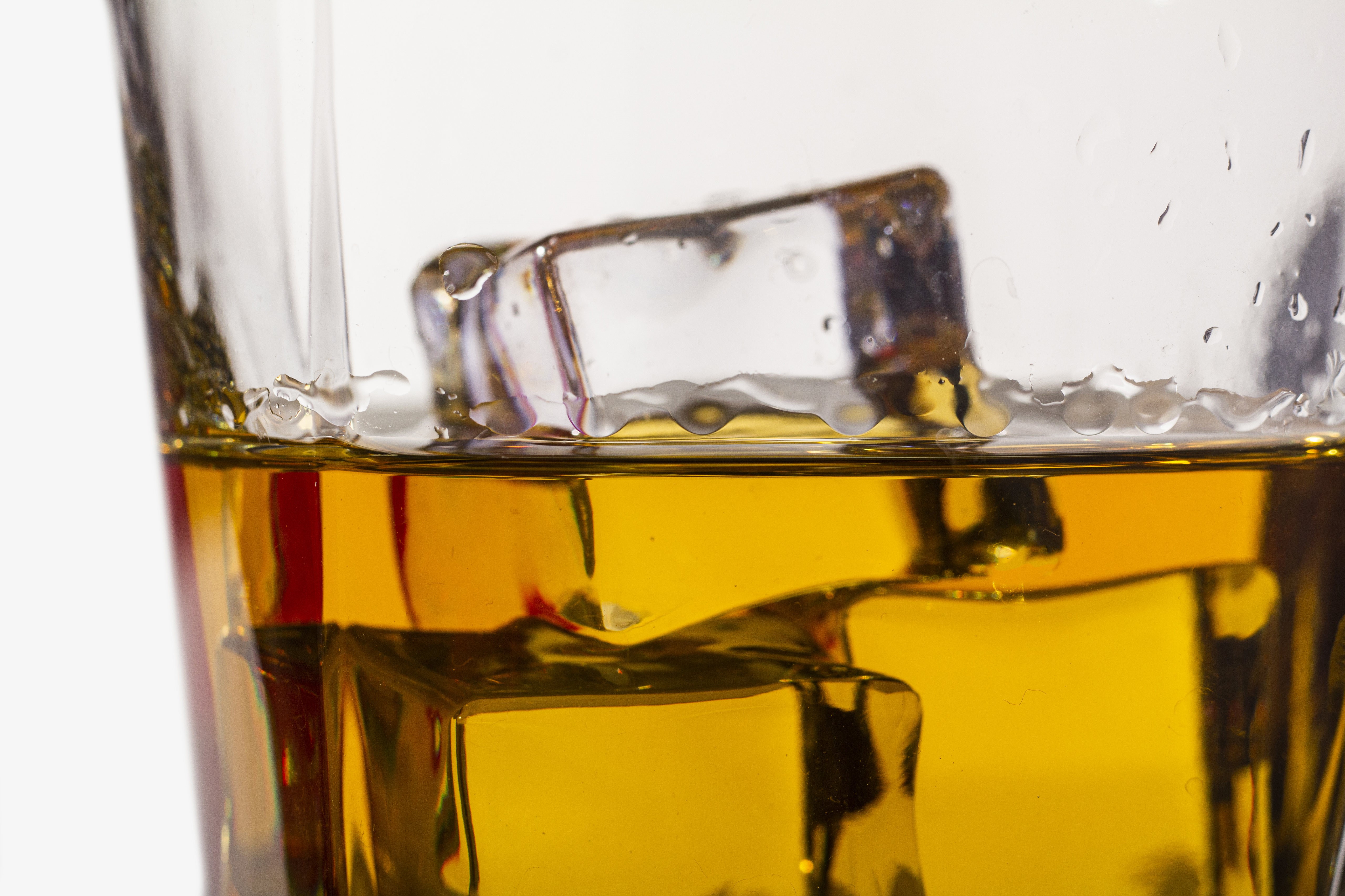 Whiskey with ice cubes in a glass HD Wallpaper