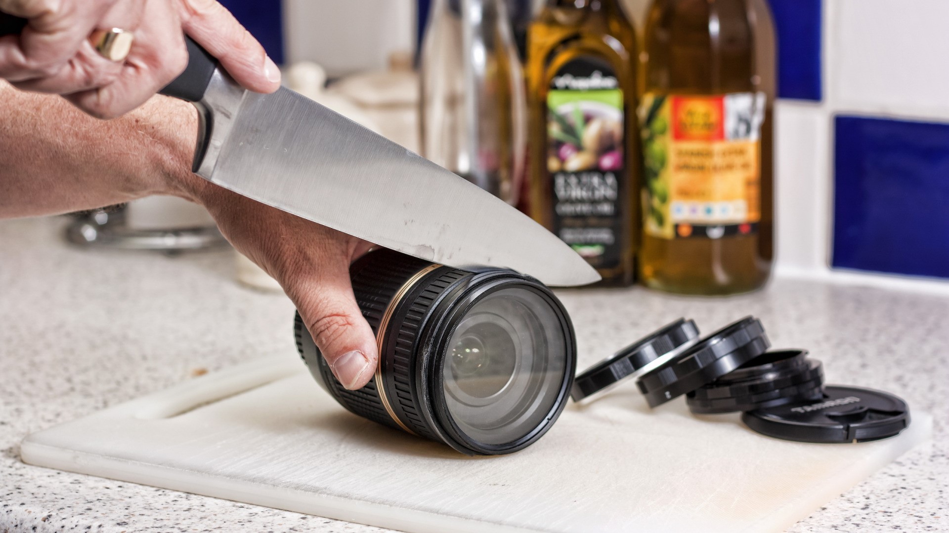 Knife cutting a camera lens on a cutting board HD Wallpaper