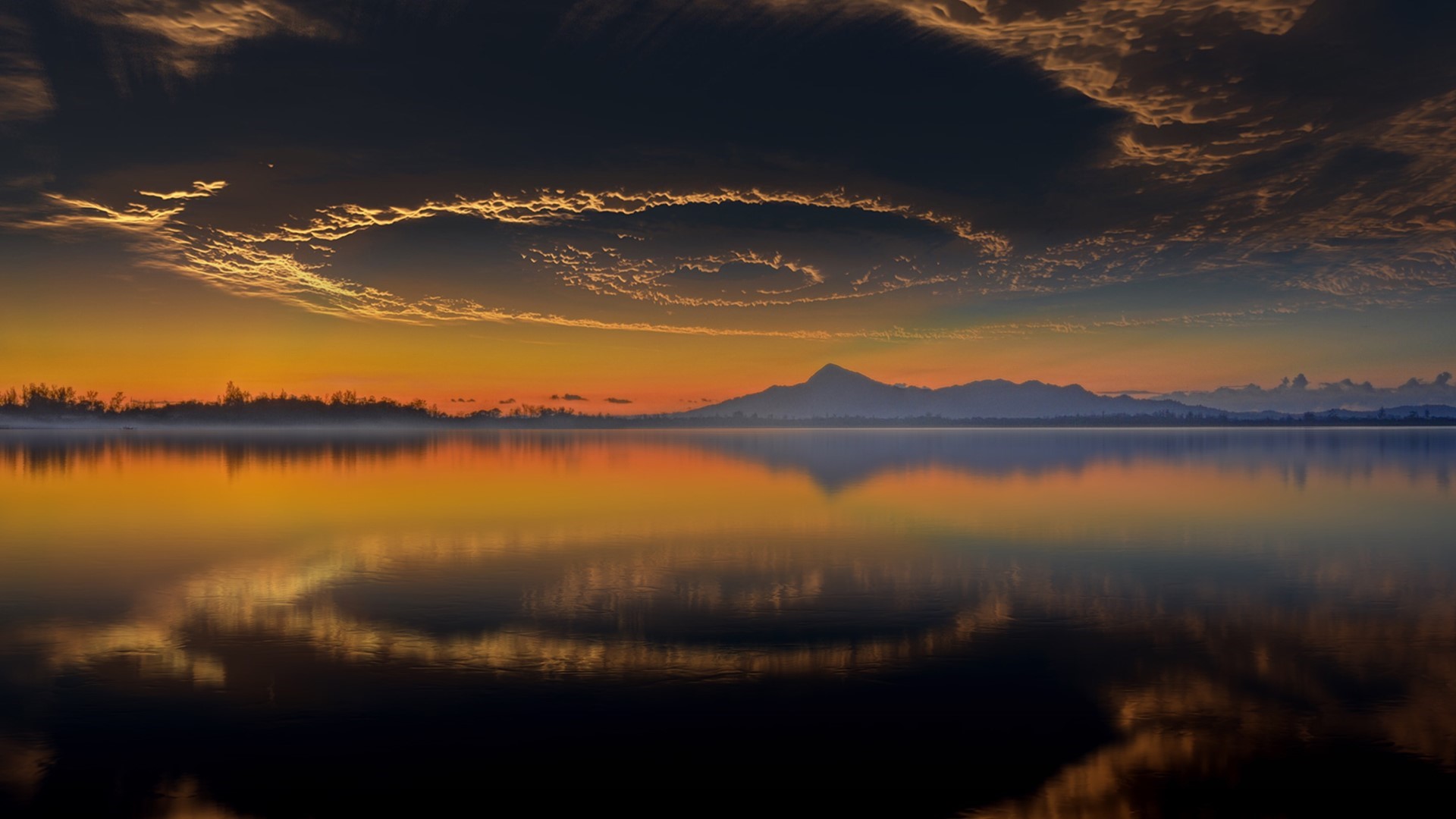 Sunset over a calm lake with mountains and clouds HD Wallpaper