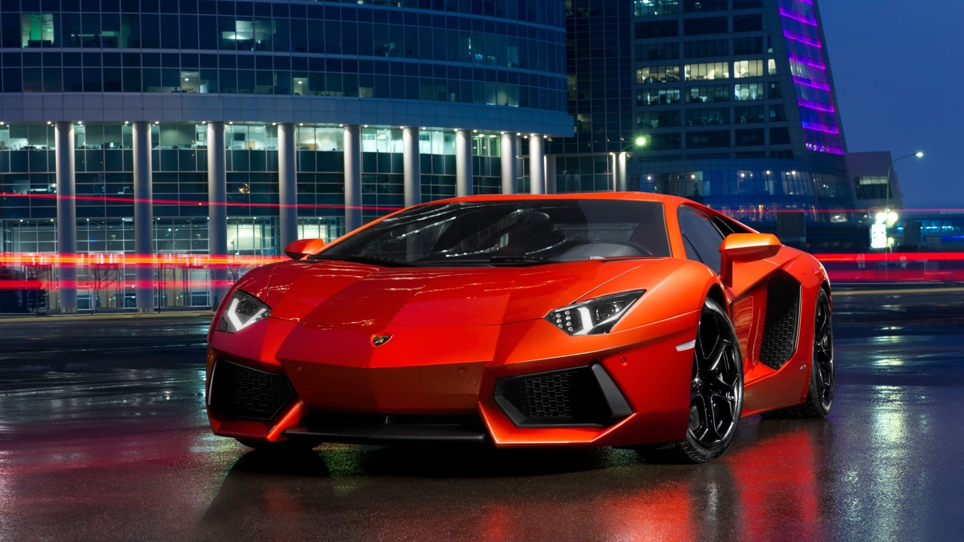 Red Lamborghini Aventador parked in a city at night HD Wallpaper